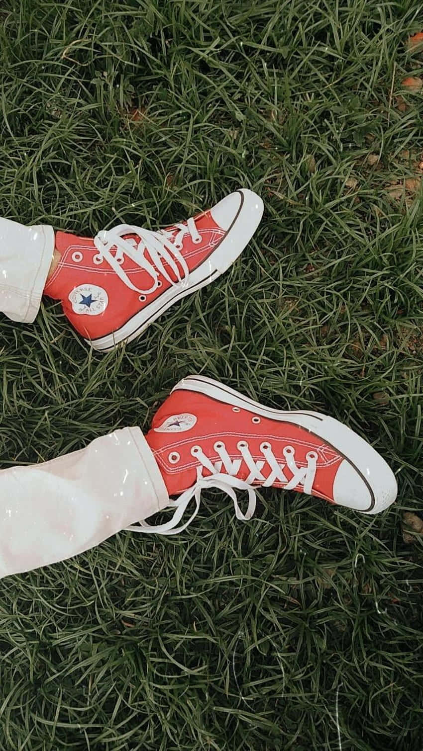 Red Shoes 桌布 壁紙 — 紅色Converse運動鞋搭配白色鞋帶，從俯視角度放置在茂密的綠色草地上。