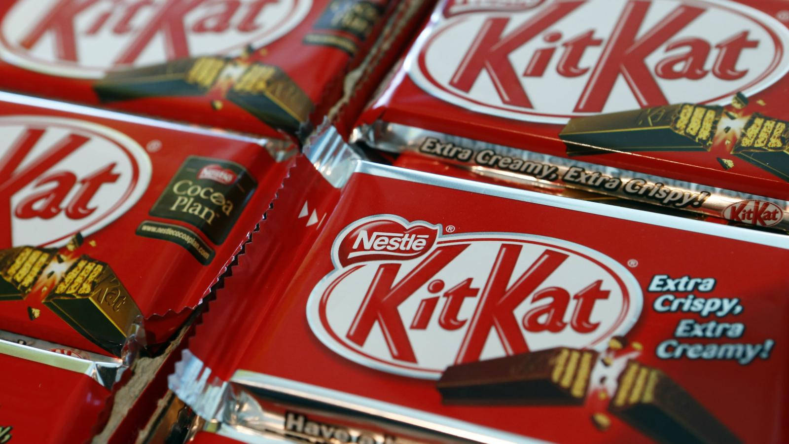 Chocolate 桌布 壁紙 — 紅色KitKat巧克力條特寫，帶有'Extra Crispy Extra Creamy'文字和金色箔紙包裝。