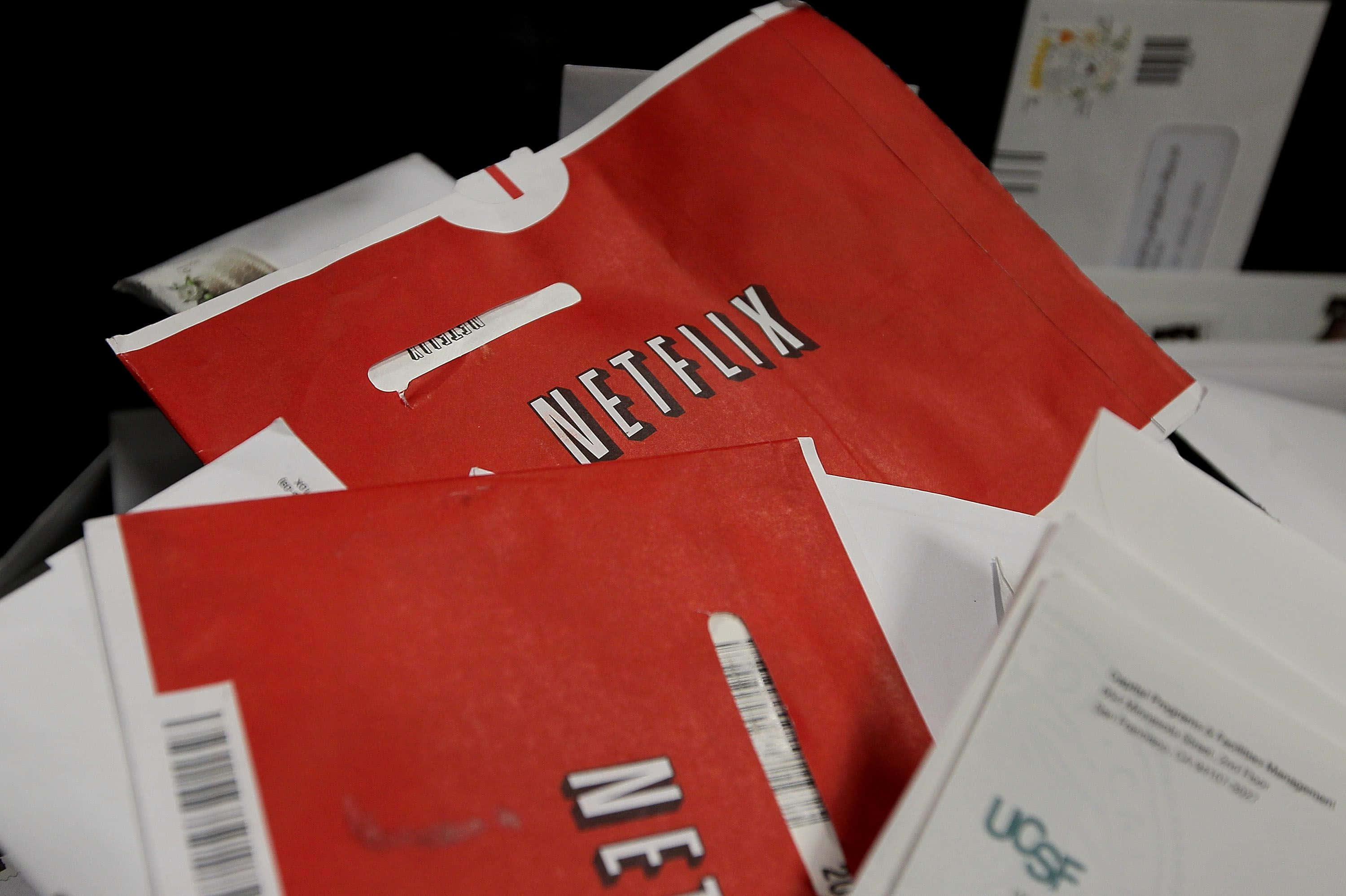 Netflix 桌布 壁紙 — 紅色Netflix郵件和白色信封堆積在雜亂的黑暗環境中。