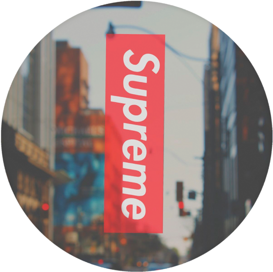 supreme 桌布 壁紙 — 紅色Supreme標誌在圓形暈影中，於模糊的城市街道背景下脫穎而出。