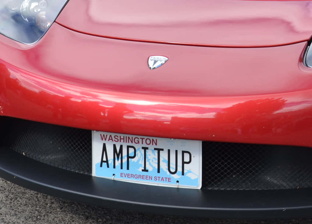 Car License Plate 桌布 壁紙 — 紅色Tesla車頭保險桿特寫，帶有華盛頓州車牌，上面寫著AMPITUP。