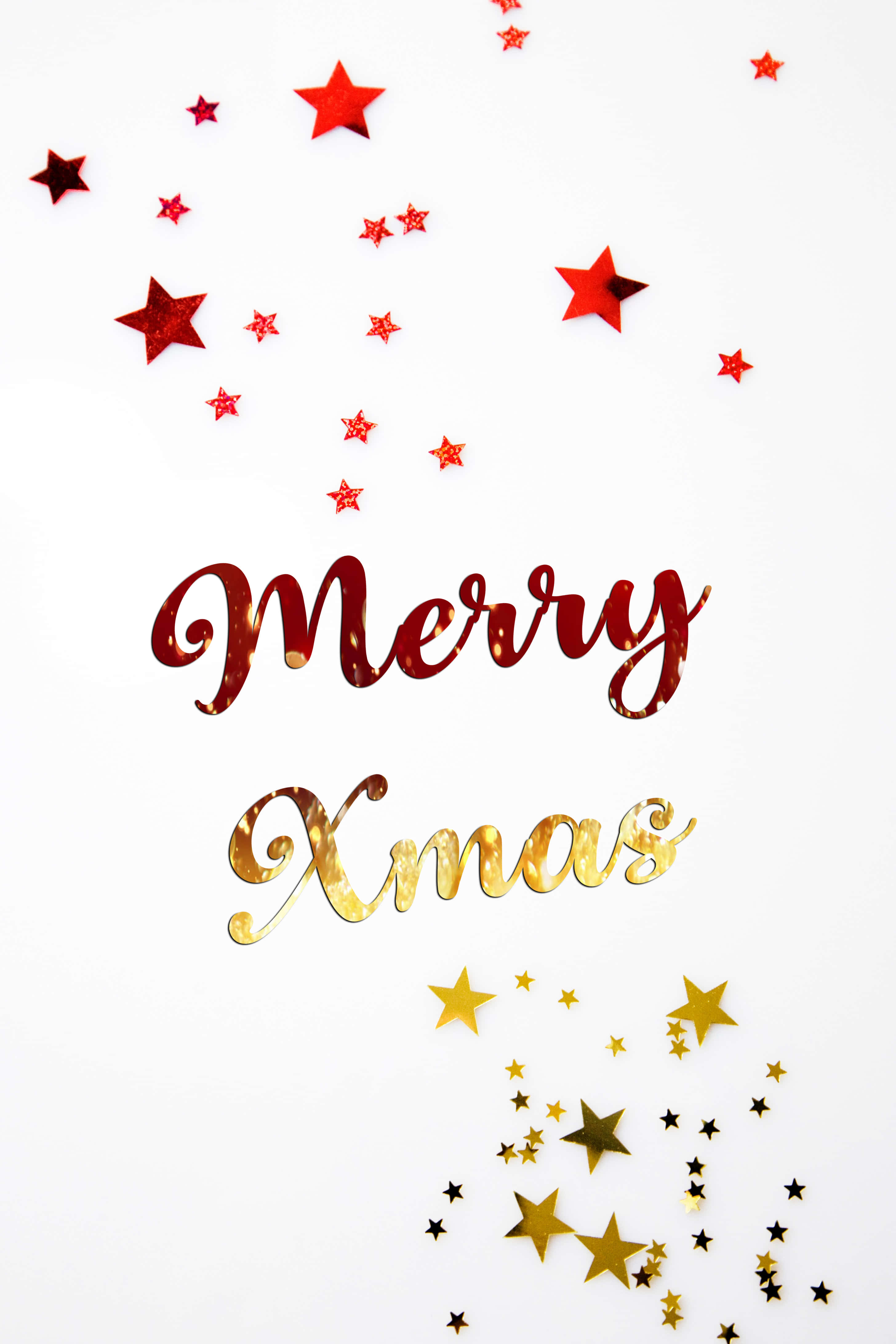 xmas 桌布 壁紙 — 紅色和金色的閃亮星星散落在優雅的手寫體 'Merry Xmas' 文字周圍，背景是純淨的白色。