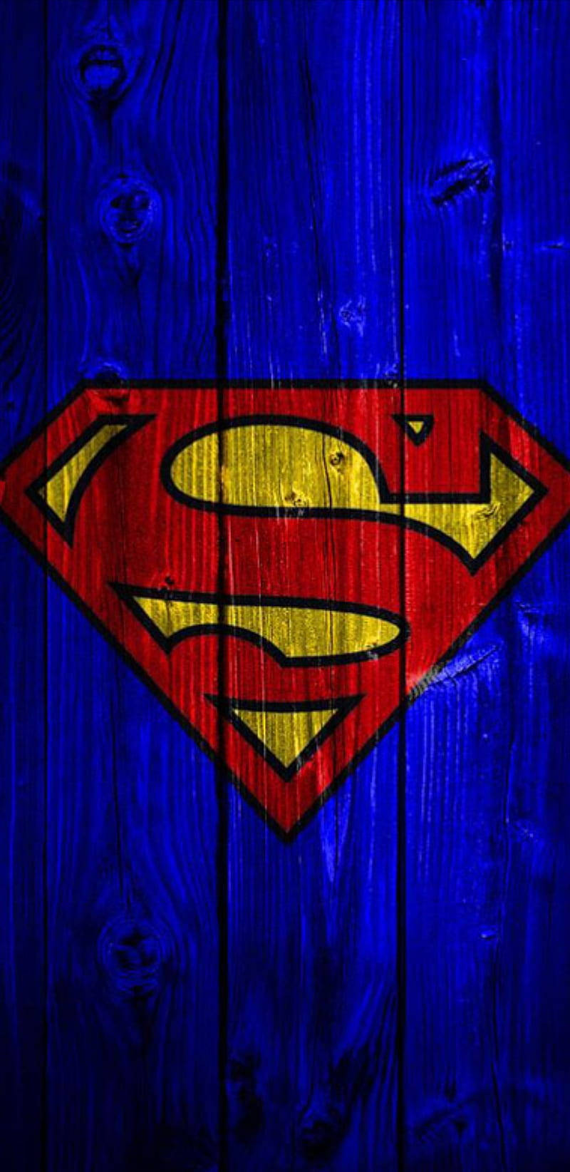 superman symbol iPhone 桌布 壁紙 — 紅色和黃色的超人標誌畫在風化的藍色木板上，可見木紋和節疤。