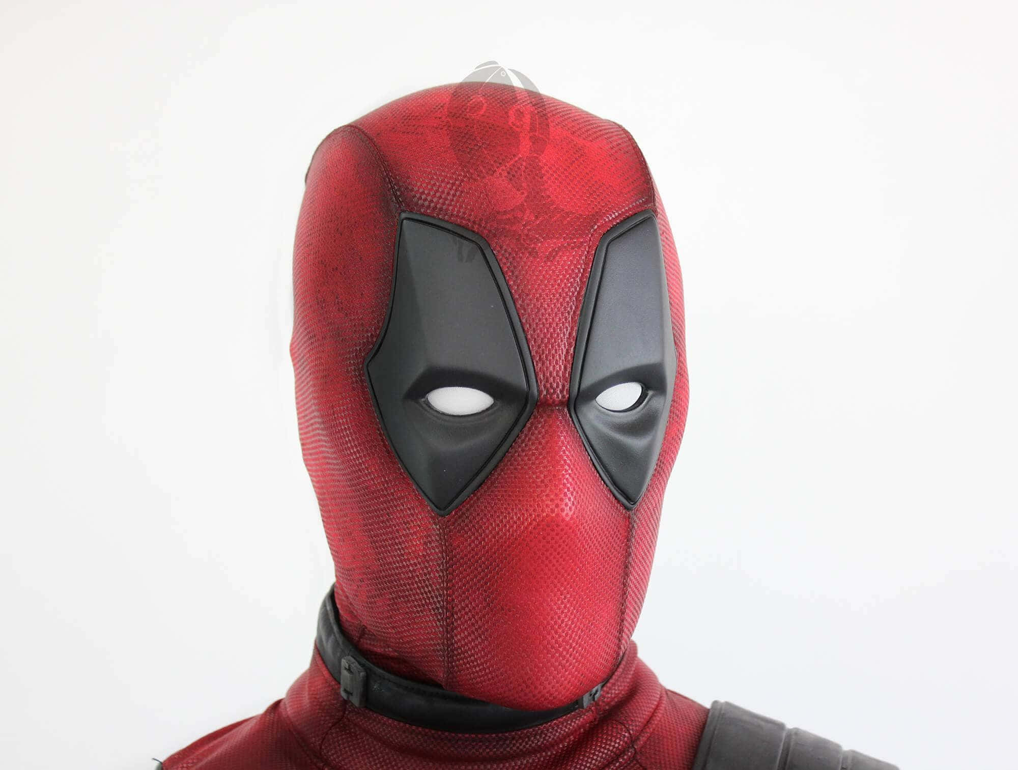 Deadpool Mask 桌布 壁紙 — 紅色和黑色死侍面具的特寫，帶有白色眼睛鏡片，背景為純白色。