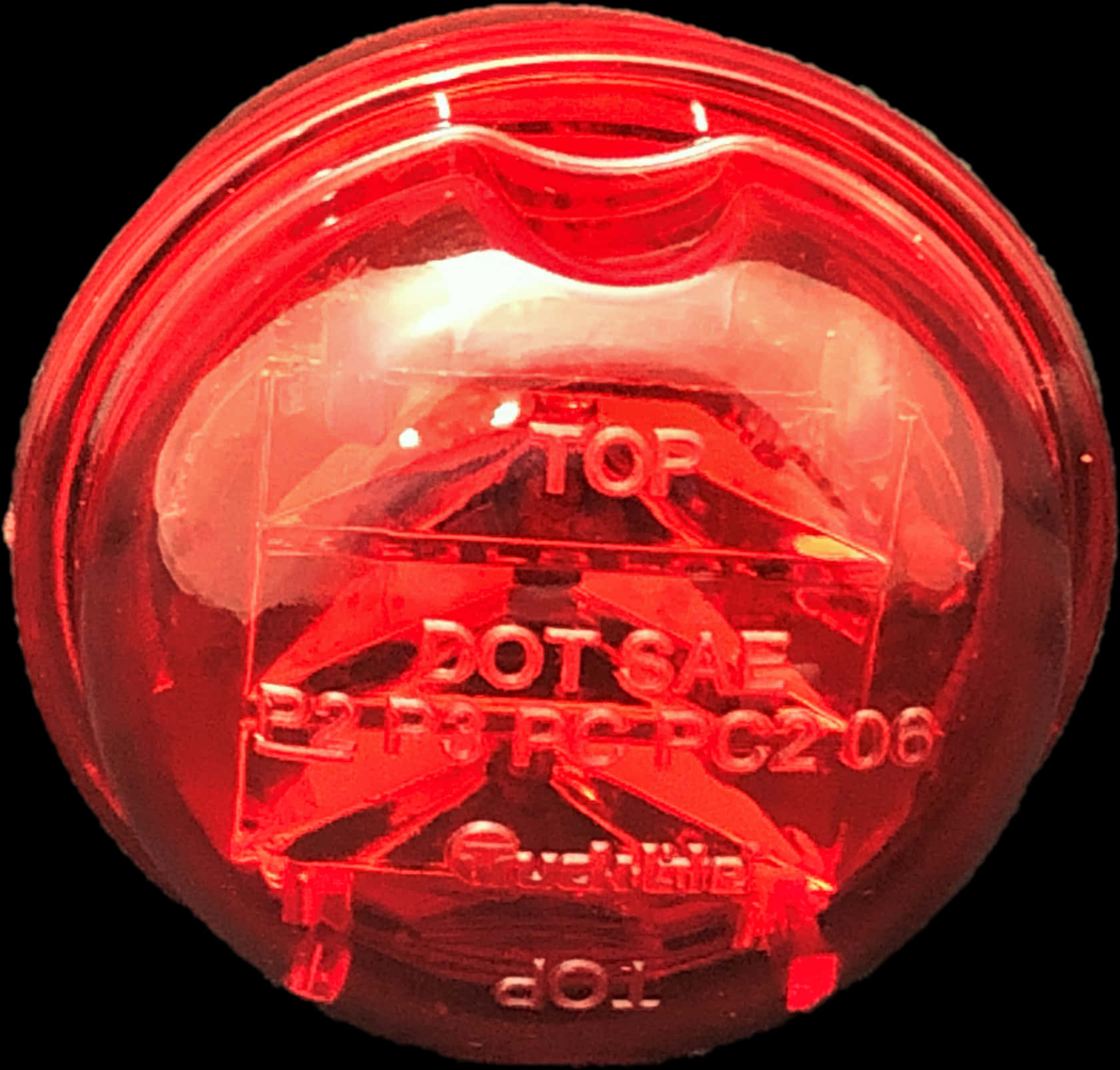 Red Light 桌布 壁紙 — 紅色圓形汽車燈鏡頭的近距離特寫，顯示壓花文字和內部結構，背景為黑色。