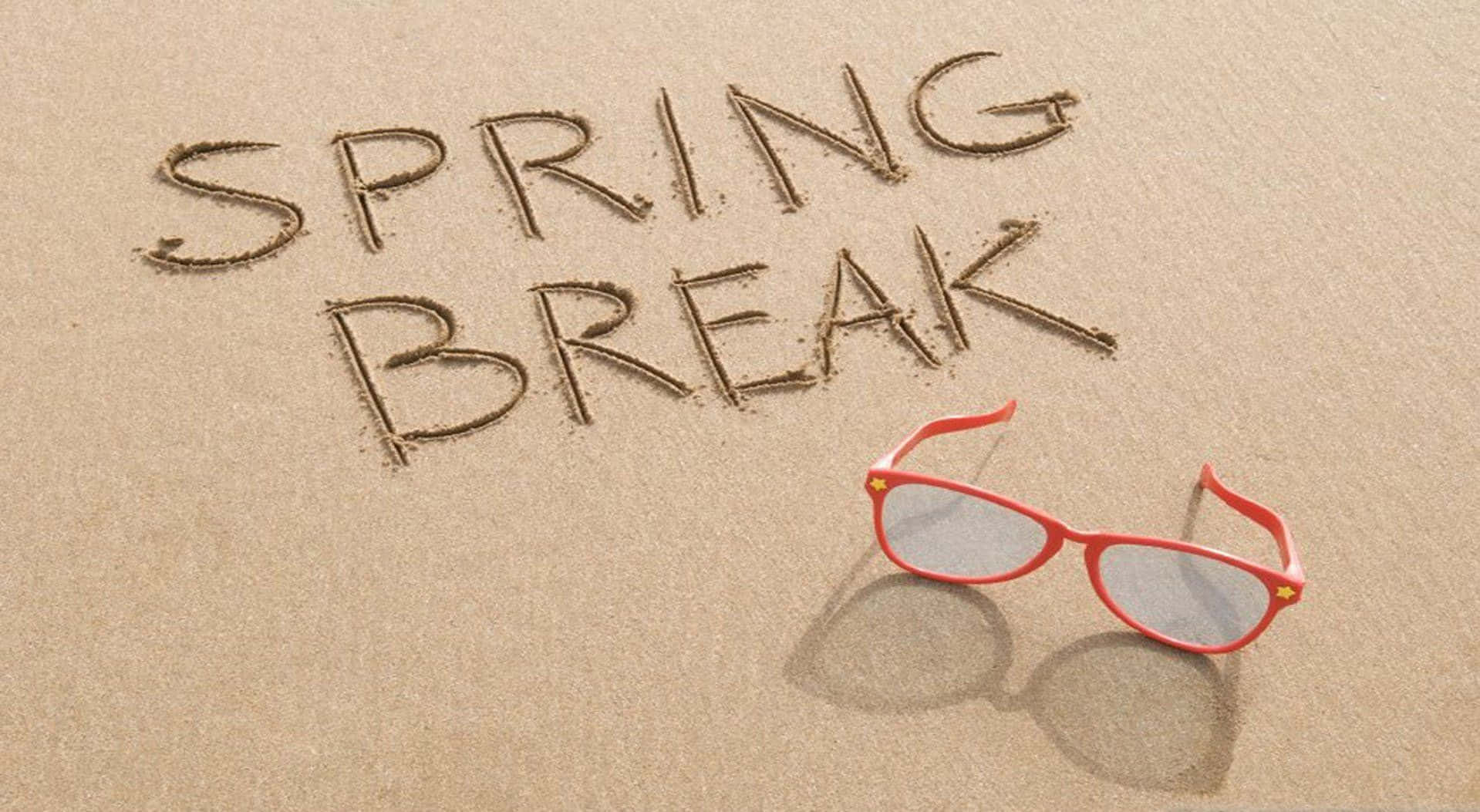 Spring Vacation 桌布 壁紙 — 紅色太陽眼鏡擱在溫暖的沙上，旁邊以鬆散字體寫著「SPRING BREAK」。