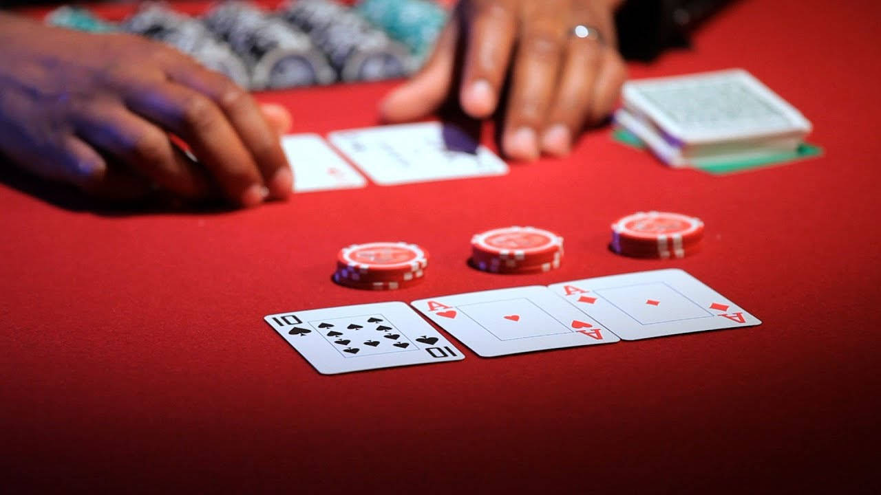 Poker 桌布 壁紙 — 紅色氈桌上玩撲克牌的手部特寫，散落著紙牌和紅色籌碼。