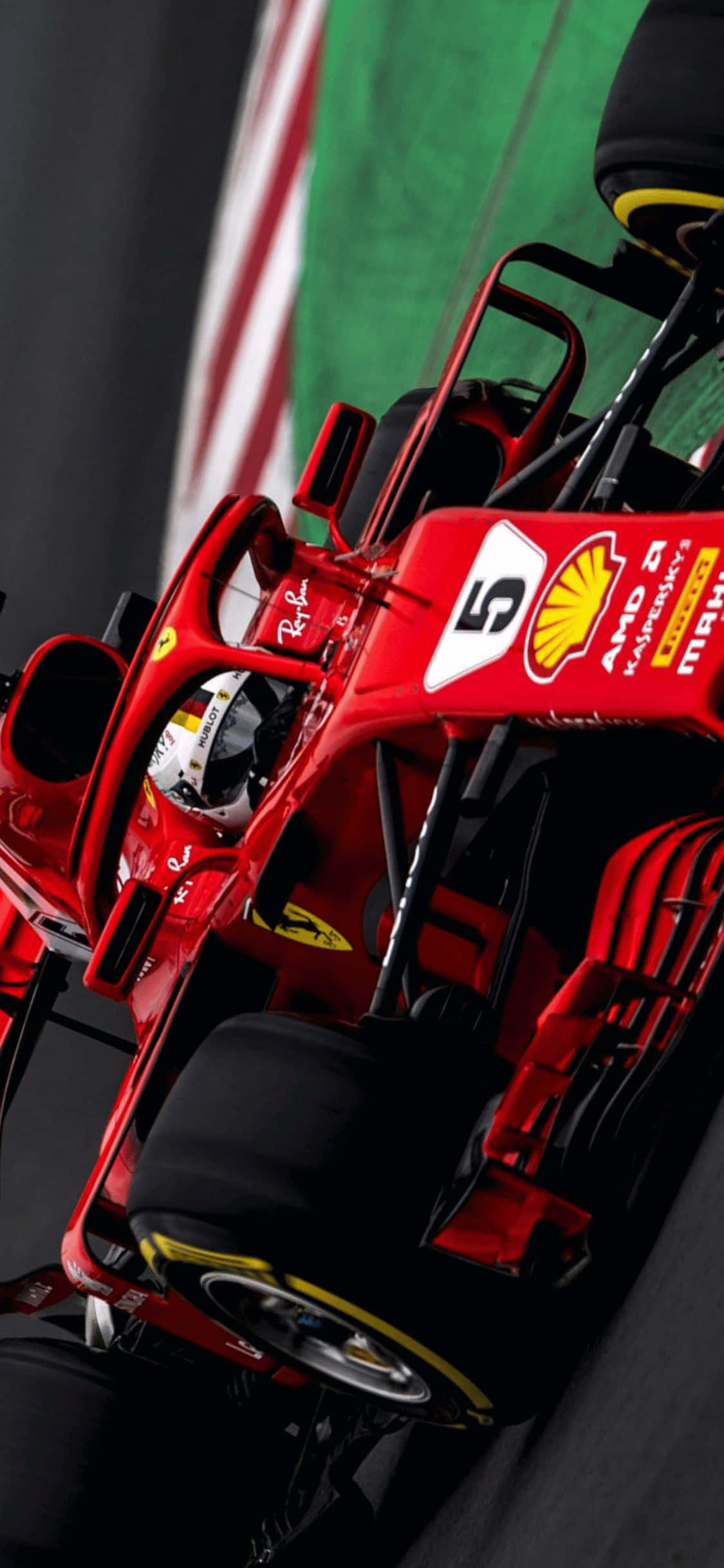 F1 2018 桌布 壁紙 — 紅色法拉利一級方程式賽車的特寫，車手頭盔在綠色和白色條紋背景上清晰可見。