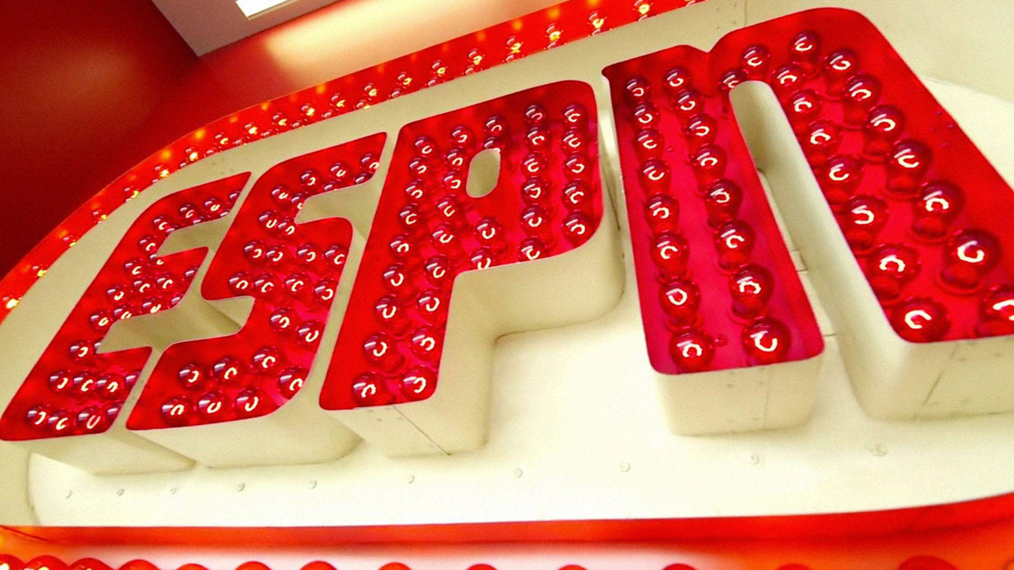 ESPN 桌布 壁紙 — 紅色牆壁上帶有白色字體和球狀燈光的發光紅色ESPN標誌特寫。