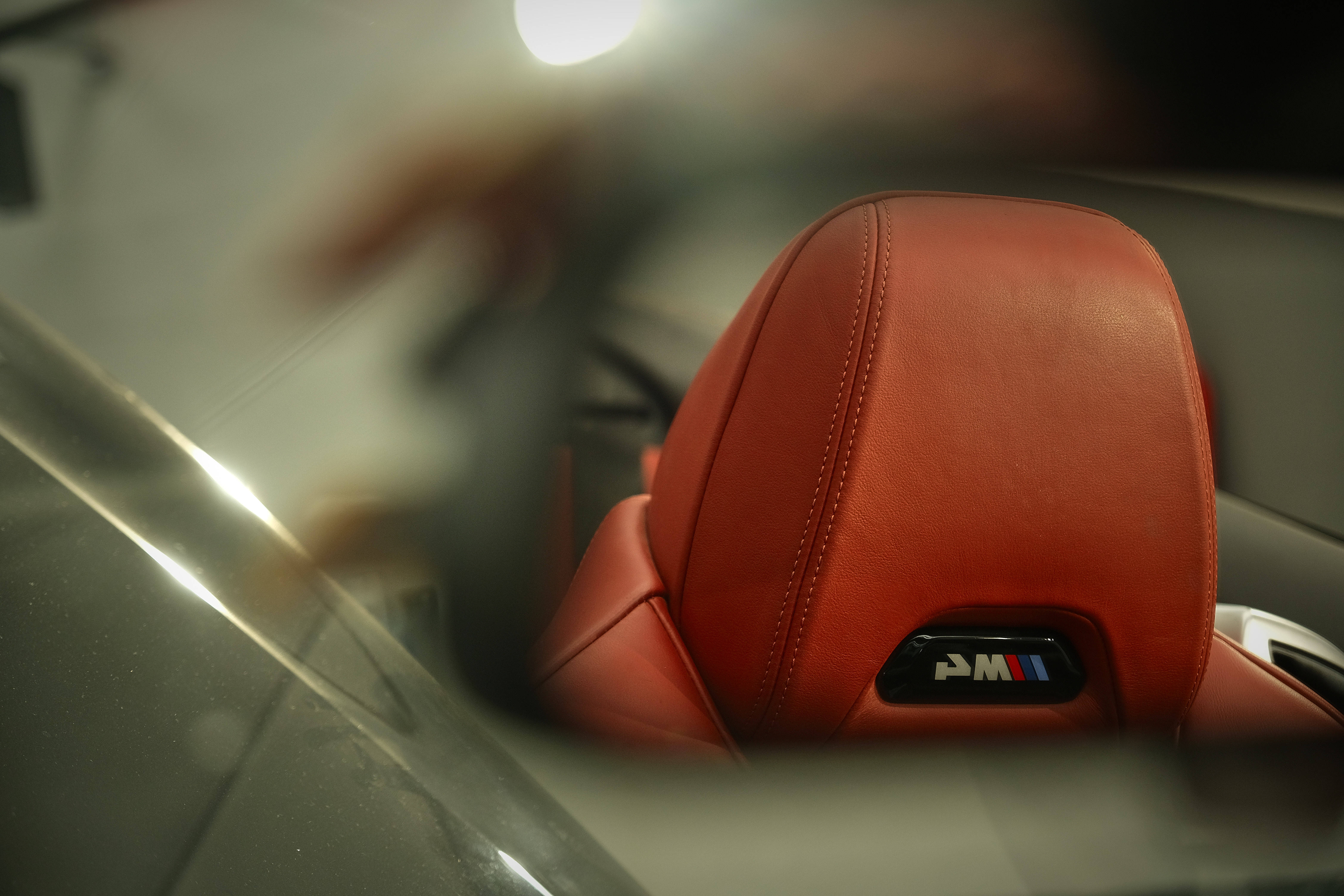 Mercedes Amg 桌布 壁紙 — 紅色皮革BMW M汽車座椅特寫，標誌透過模糊的玻璃表面可見。