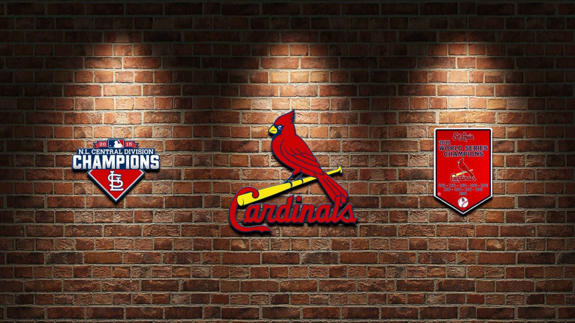 Cardinals 桌布 壁紙 — 紅色紅雀標誌和冠軍補丁在聚光燈下在紋理磚牆上發光。
