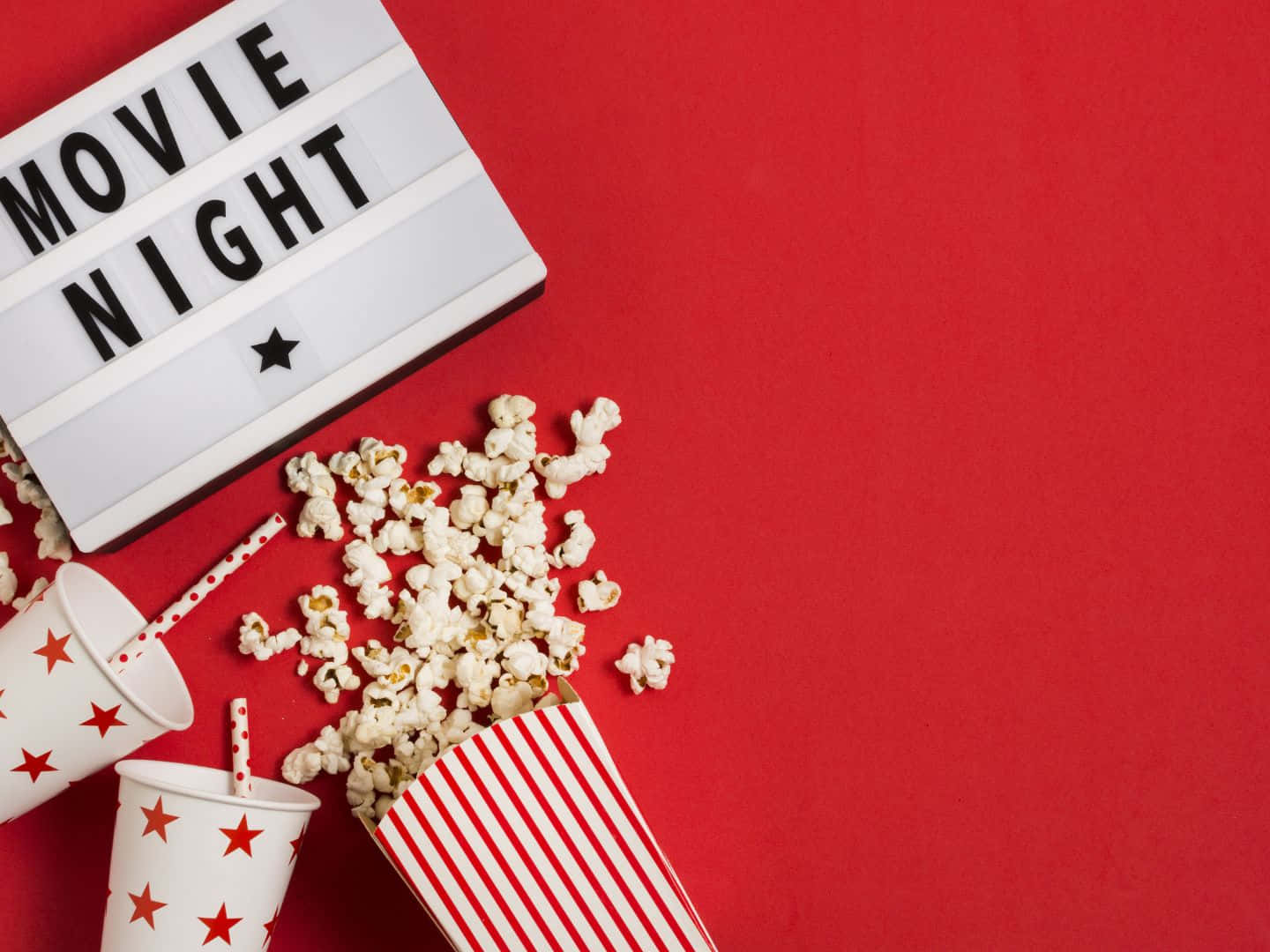 1440x1080 桌布 壁紙 — 紅色背景上有一個發光箱，上面寫著「MOVIE NIGHT」，旁邊有灑出的爆米花和星星圖案的杯子。