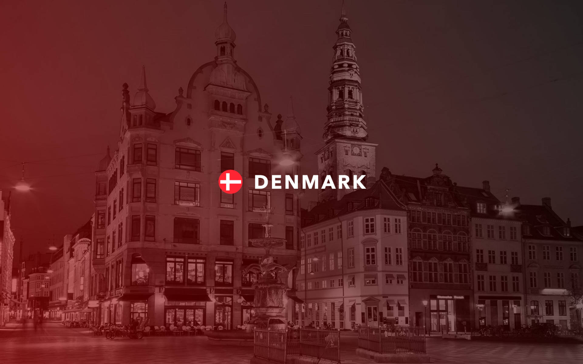 Denmark 桌布 壁紙 — 紅色調的丹麥歷史建築夜景，突出教堂塔樓和燈火通明的建築物。