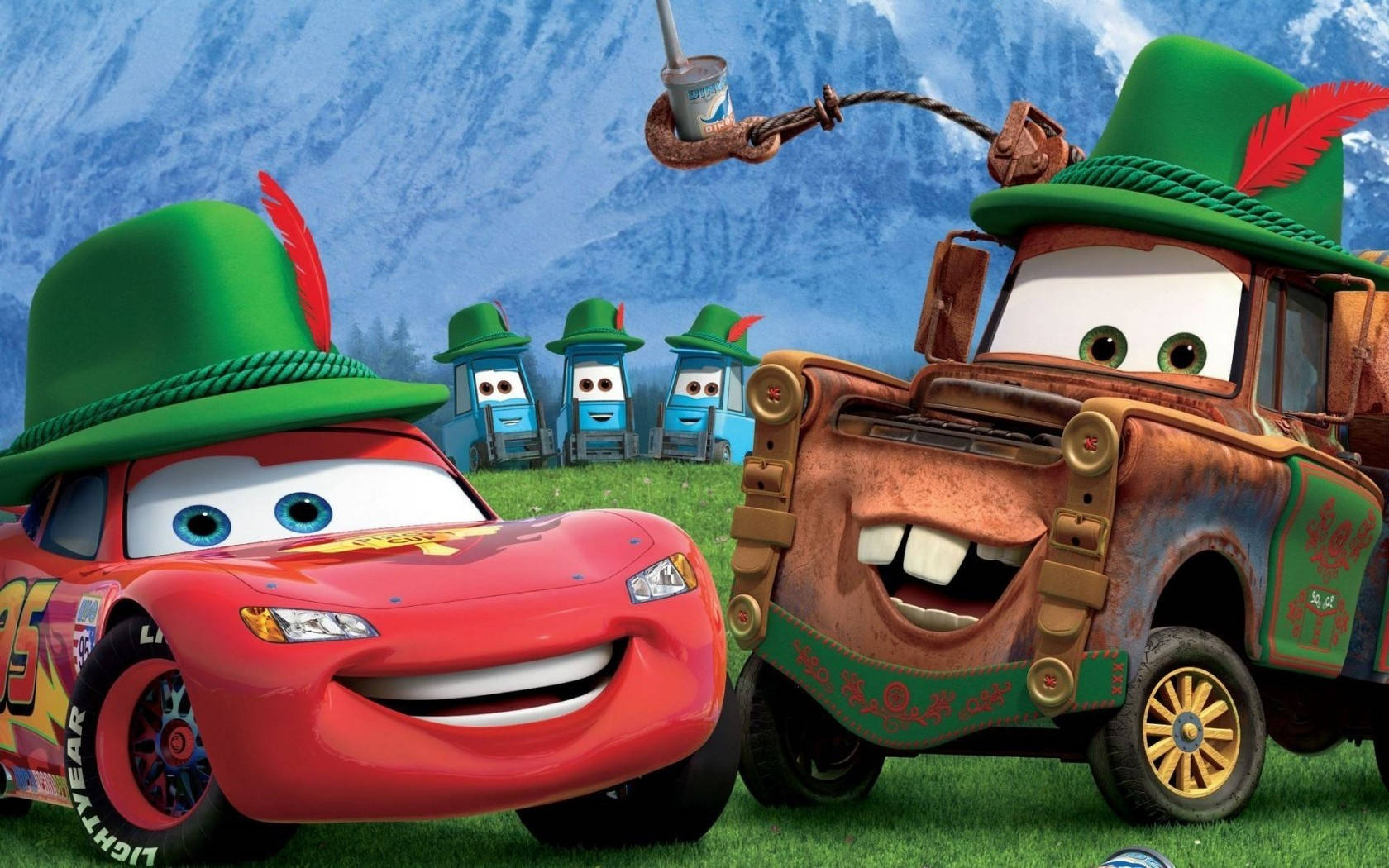 cars 桌布 壁紙 — 紅色賽車和生鏽的拖車戴著綠色帽子，在長滿草的山丘上微笑，背後是白雪覆蓋的山脈。