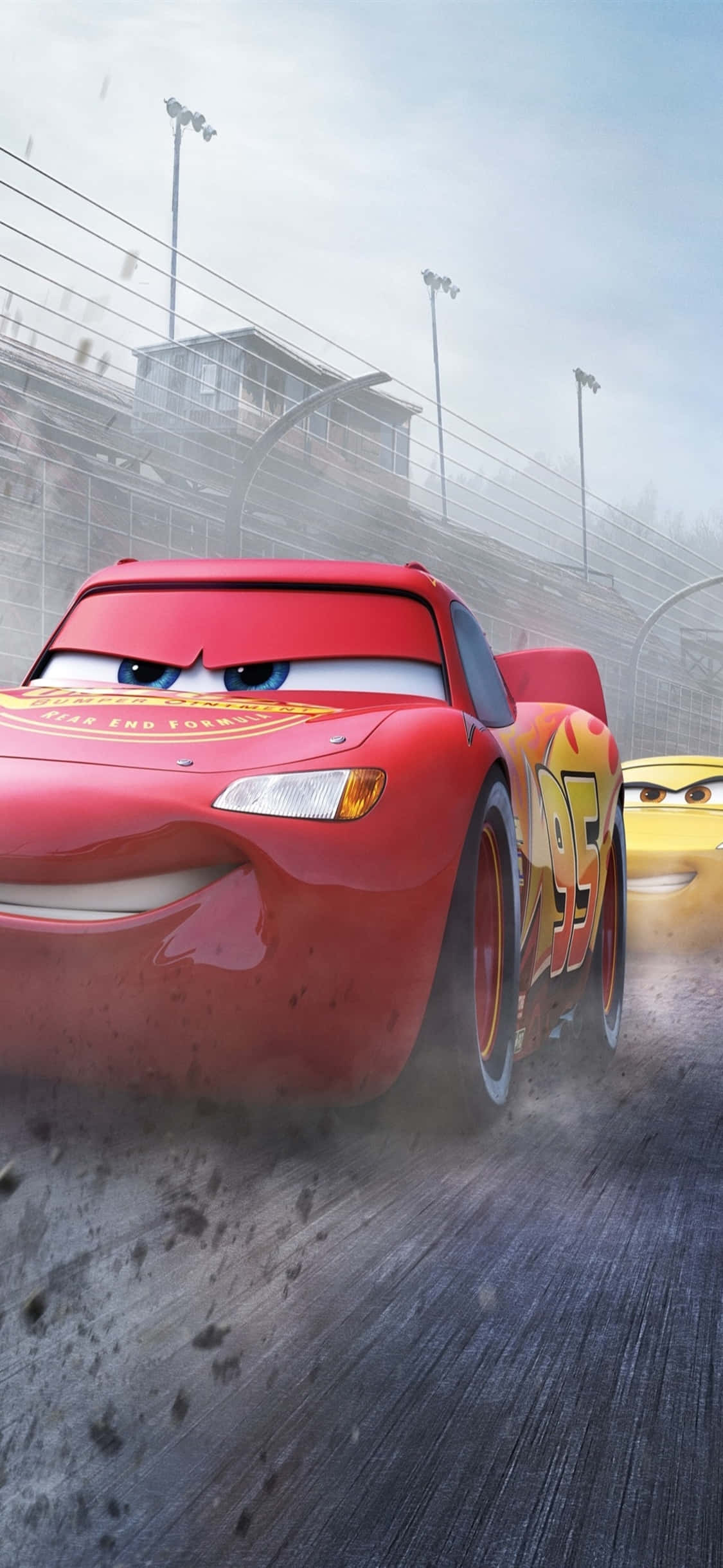 Lightning Mcqueen 桌布 壁紙 — 紅色賽車閃電麥坤在塵土飛揚的賽道上疾馳，黃色車拖線陪伴在旁，天空多雲。