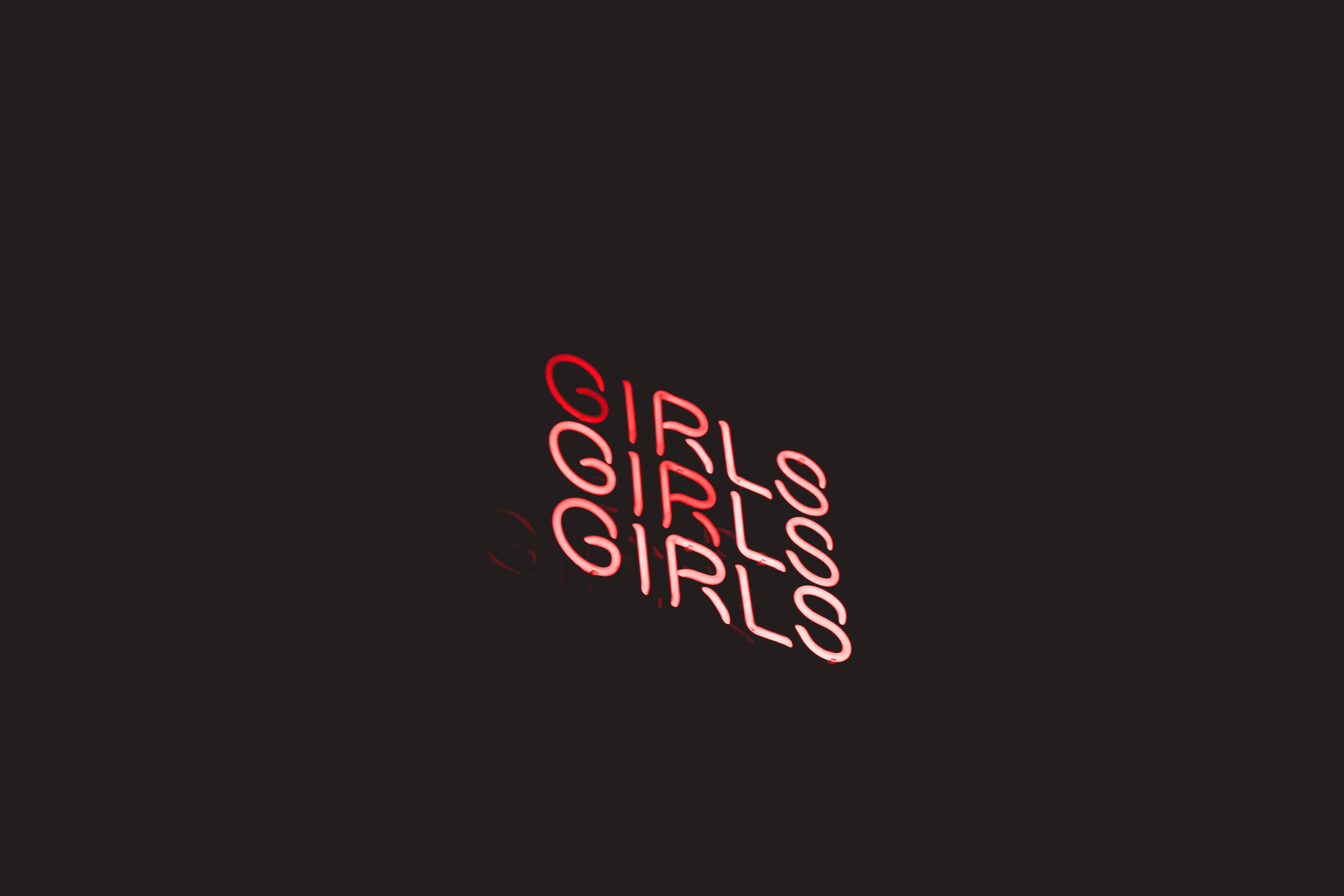 neon sign 桌布 壁紙 — 紅色霓虹燈文字拼寫GIRLS，在深色背景上對角重複。
