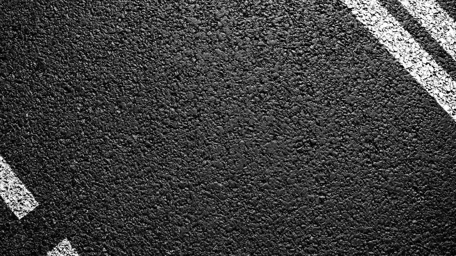 black textured 桌布 壁紙 — 紋理黑色瀝青路面近距離特寫，帶有清晰白色漆面車道標記。