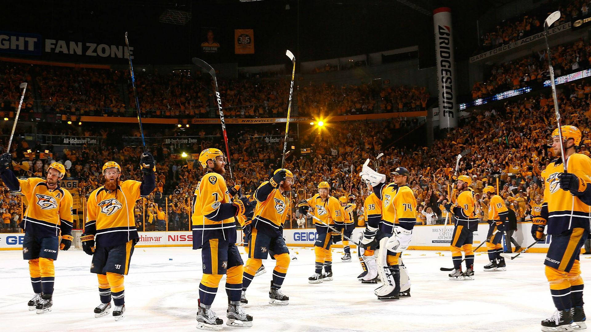 Predators 桌布 壁紙 — 納什維爾掠奪者冰球球員在冰上高舉球棍慶祝勝利，咆哮的球迷擠滿了場館。