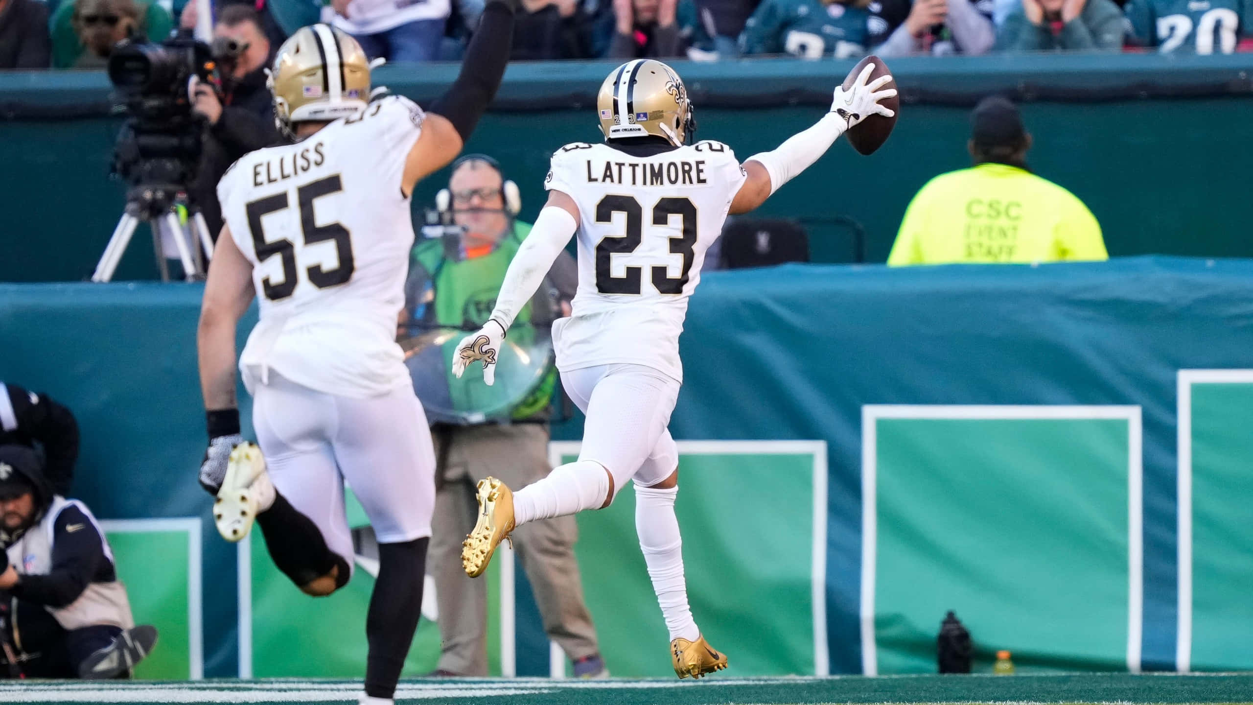 New Orleans Saints 桌布 壁紙 — 紐奧良聖徒隊23號球員跳起接住足球，勝利在望，隊友55號在場上他身後慶祝。