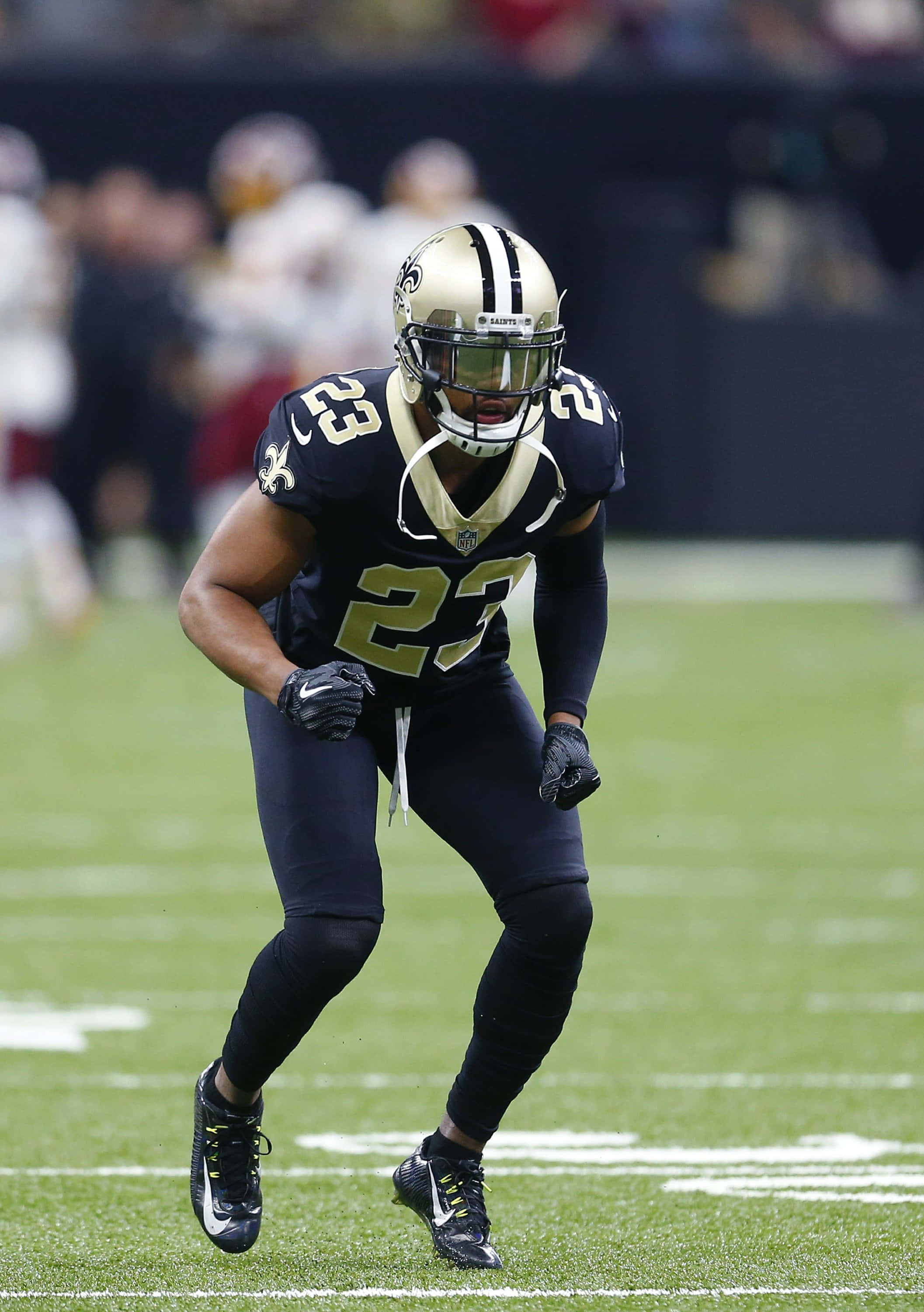 New Orleans Saints 桌布 壁紙 — 紐奧良聖徒隊23號美式足球員在比賽中衝過綠色球場。