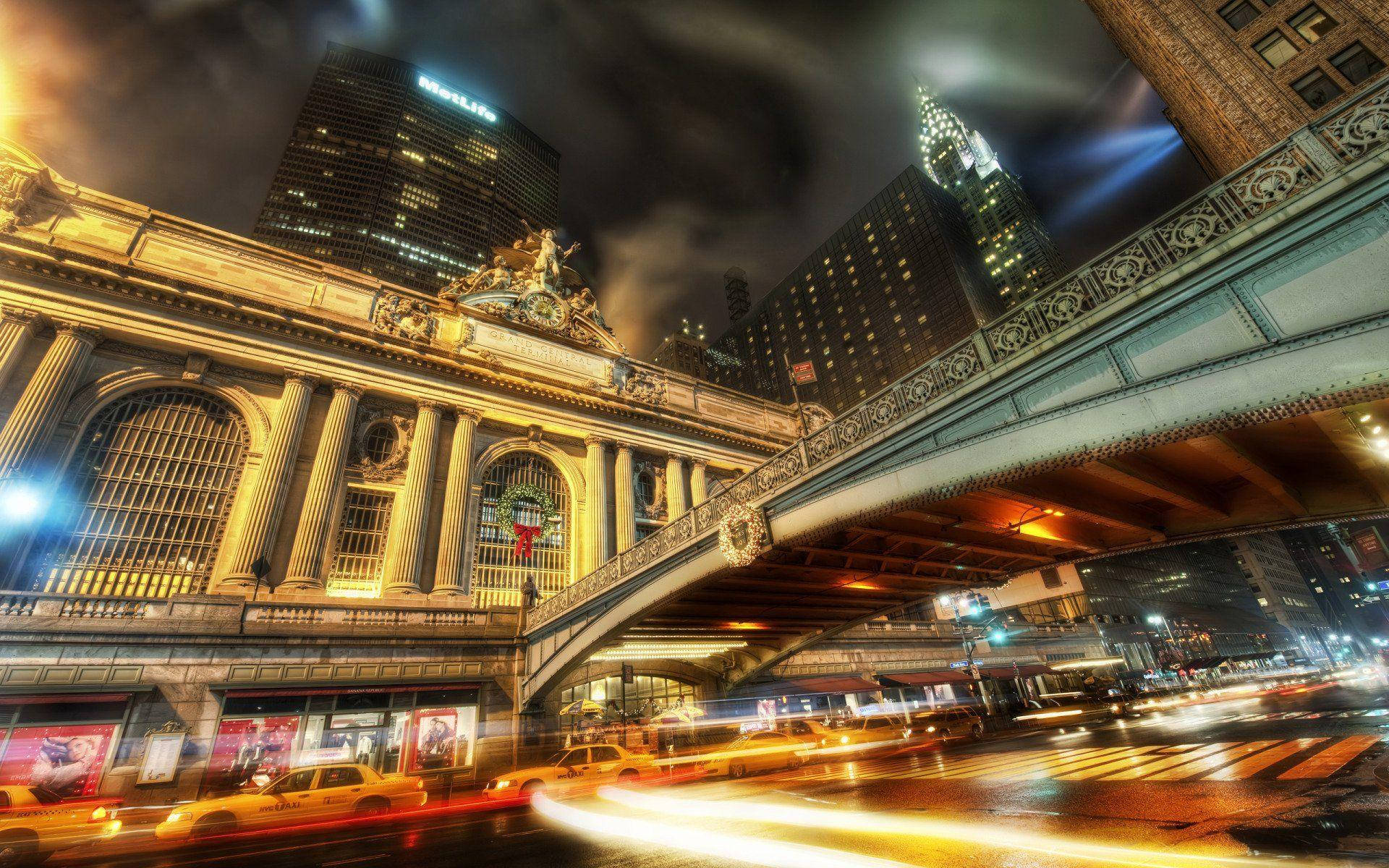 筆電 桌布 壁紙 — 紐約中央車站的充滿活力的夜景照片，黃色計程車的光跡和摩天大樓在黑暗的天空下閃耀。