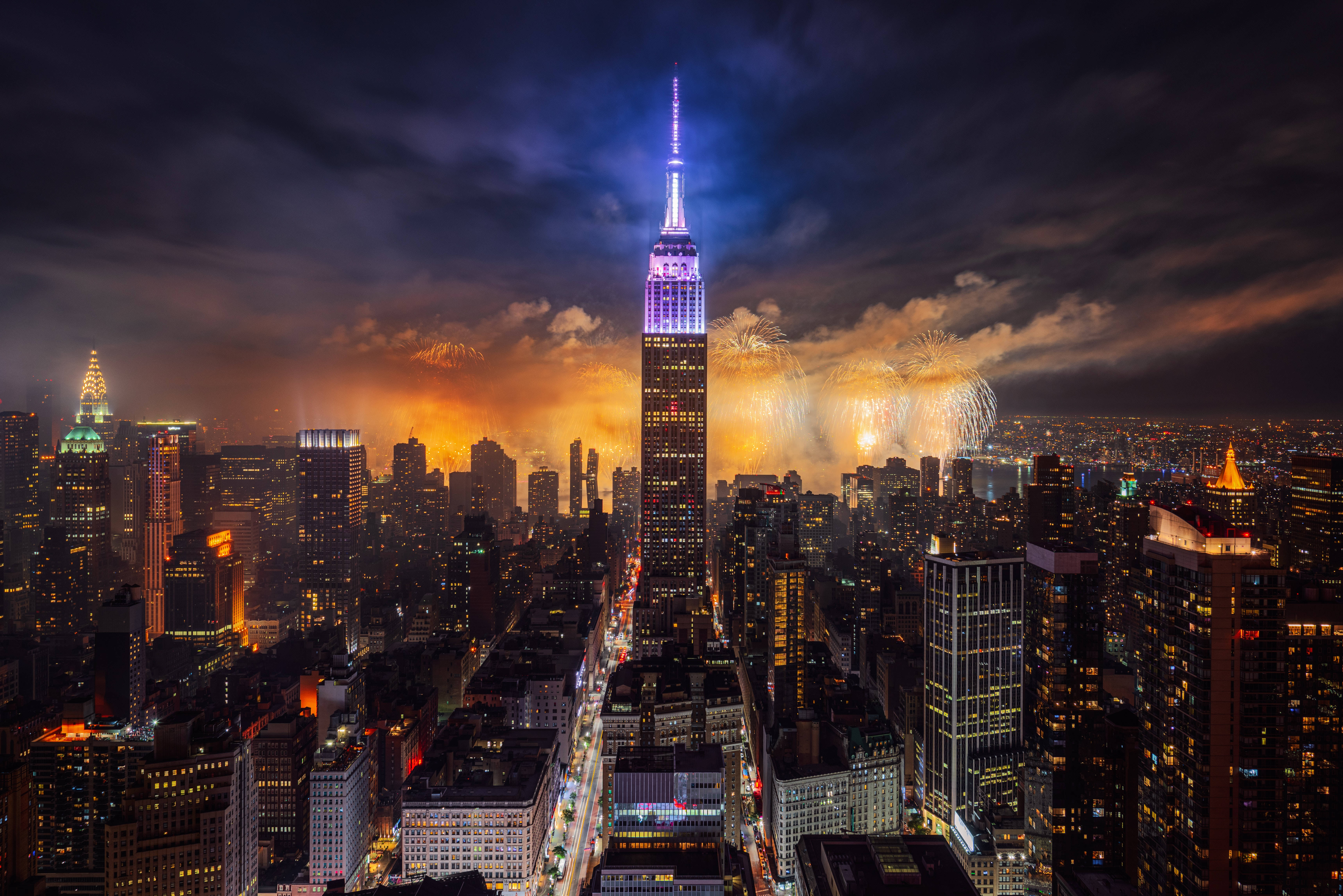 empire state 桌布 壁紙 — 紐約令人目眩的夜景，帝國大廈燈火通明，煙火在天空中綻放。