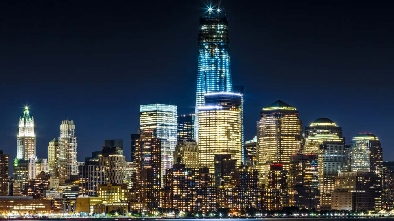 1366x768 Empire State Building 桌布 壁紙 — 紐約令人眼花撩亂的夜景，摩天大樓在深藍色天空下閃耀。