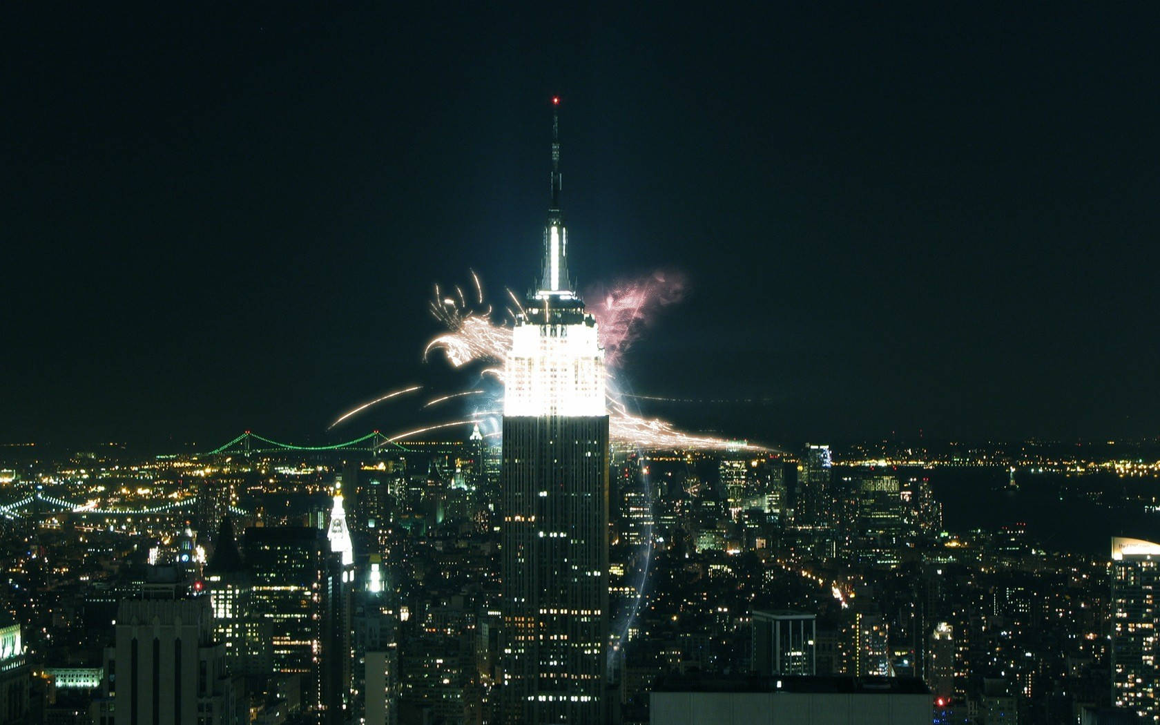 empire 桌布 壁紙 — 紐約令人眼花撩亂的夜景，煙火在燈火通明的帝國大廈周圍爆炸。