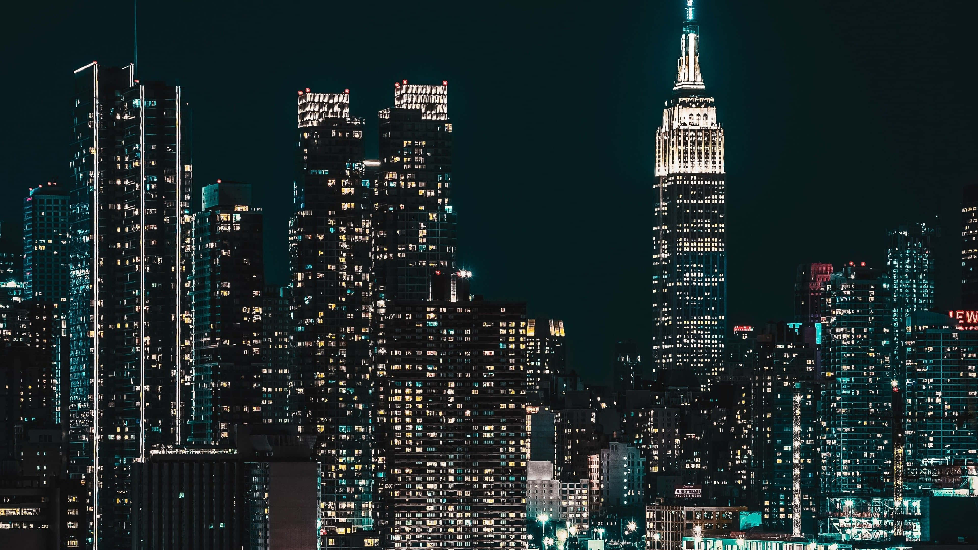 夜空 桌布 壁紙 — 紐約令人驚嘆的夜景，帝國大廈在高聳的摩天大樓中閃耀著光芒。