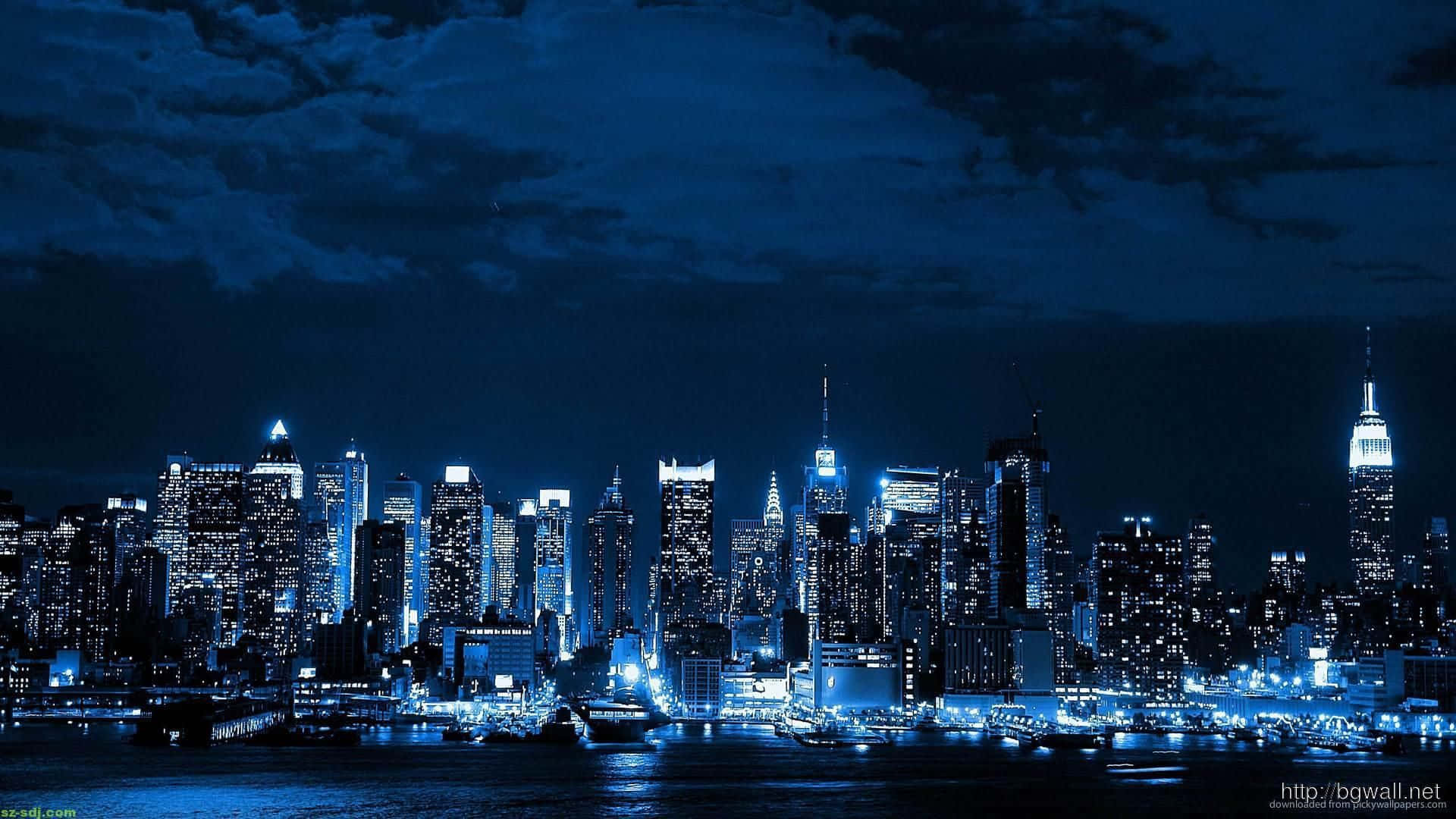 夜景城市 桌布 壁紙 — 紐約令人驚嘆的夜景，摩天大樓在深藍色天空下在水面上閃閃發光。