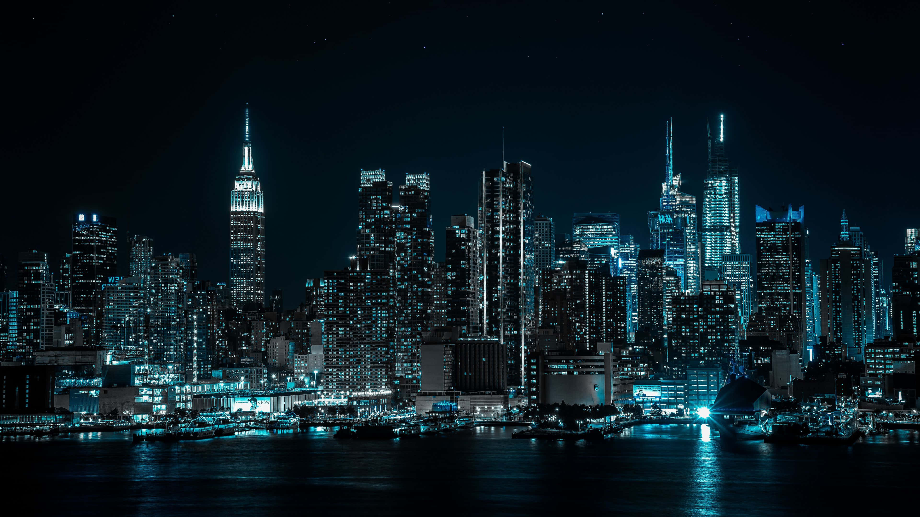 桌布 壁紙 — 紐約令人驚嘆的夜景，閃爍的摩天大樓在星空下倒映在黑暗的水面上。