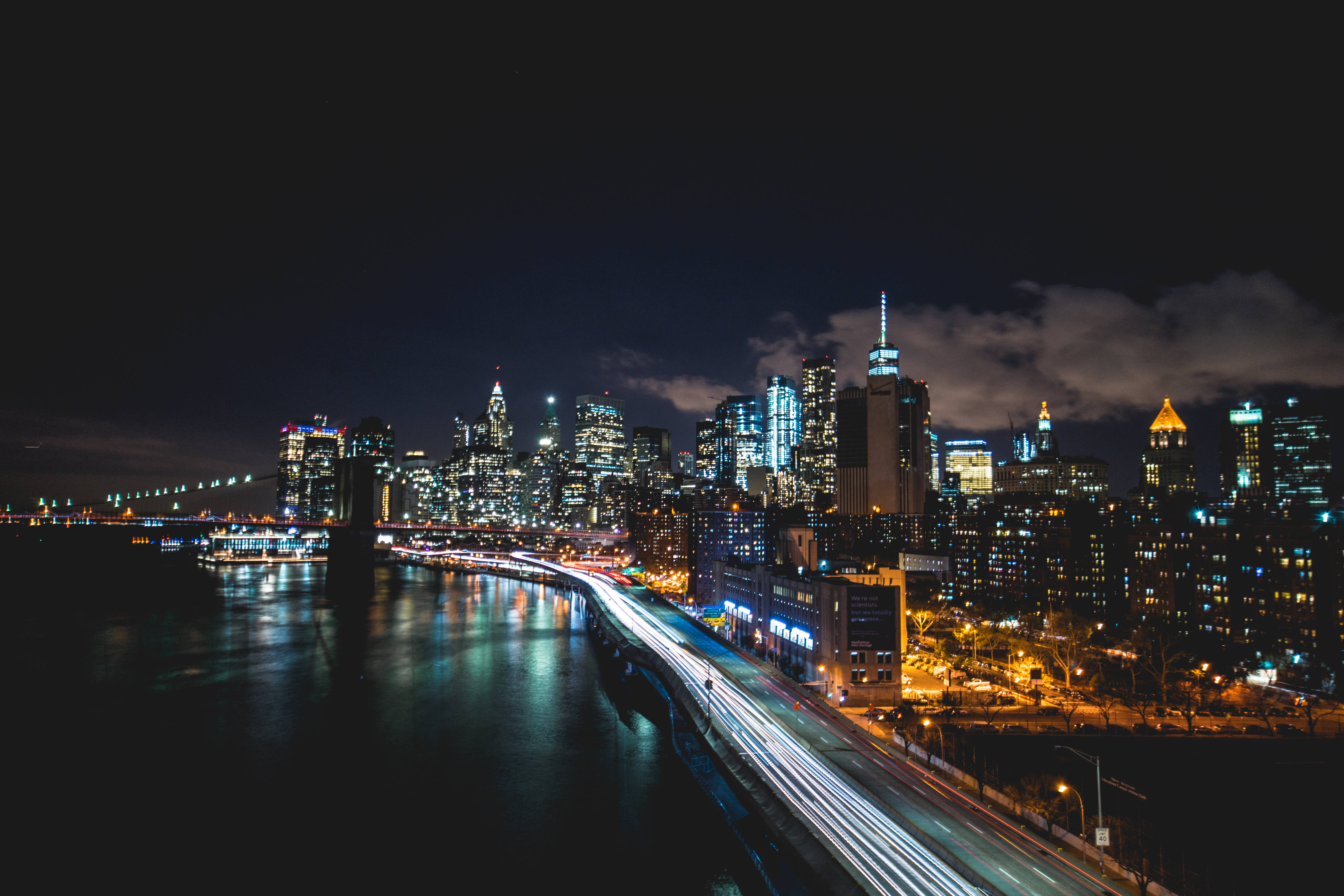New 桌布 壁紙 — 紐約充滿活力的夜景，閃爍的摩天大樓和海濱道路上的車流光軌。