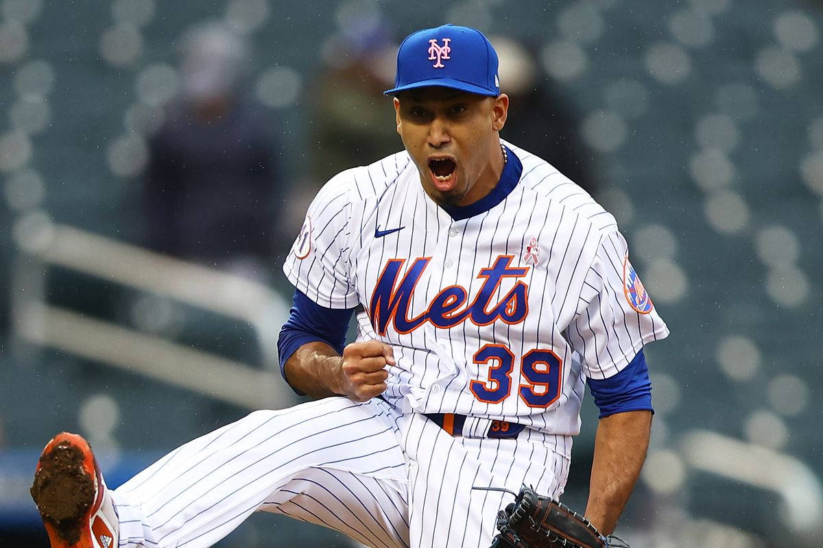 MLB 桌布 壁紙 — 紐約大都會棒球投手在雨天比賽中，以高度專注和動態動作進行投球的瞬間。