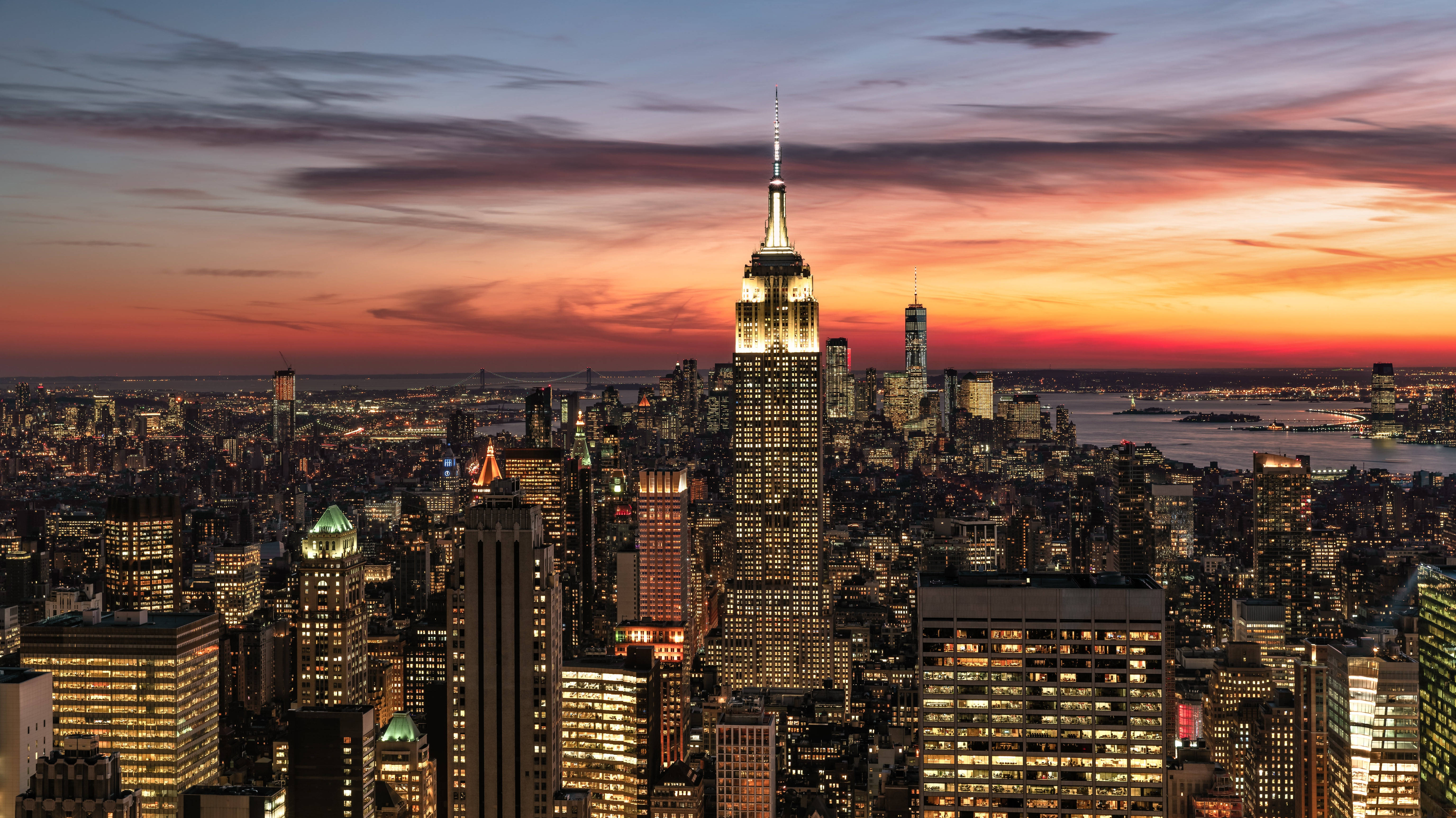 New York 桌布 壁紙 — 紐約天際線的壯麗日落，帝國大廈在熾熱的橙色和紫色雲彩中閃耀。