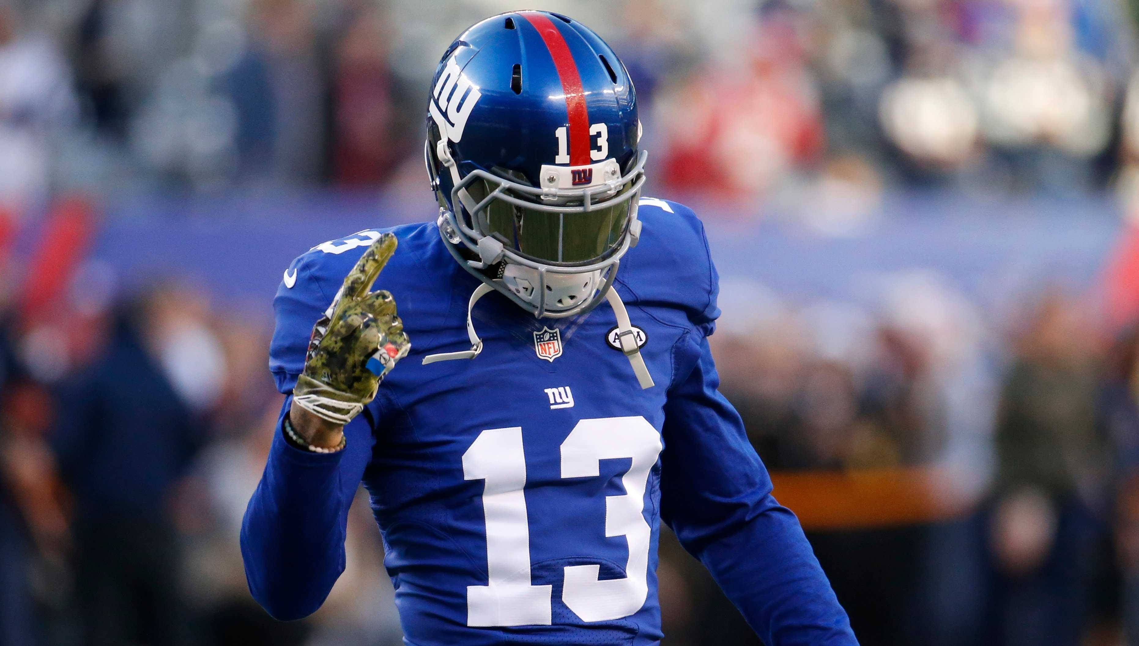 Odell 桌布 壁紙 — 紐約巨人隊美式足球員13號身穿藍色球衣，在比賽中戴手套的手向上指。