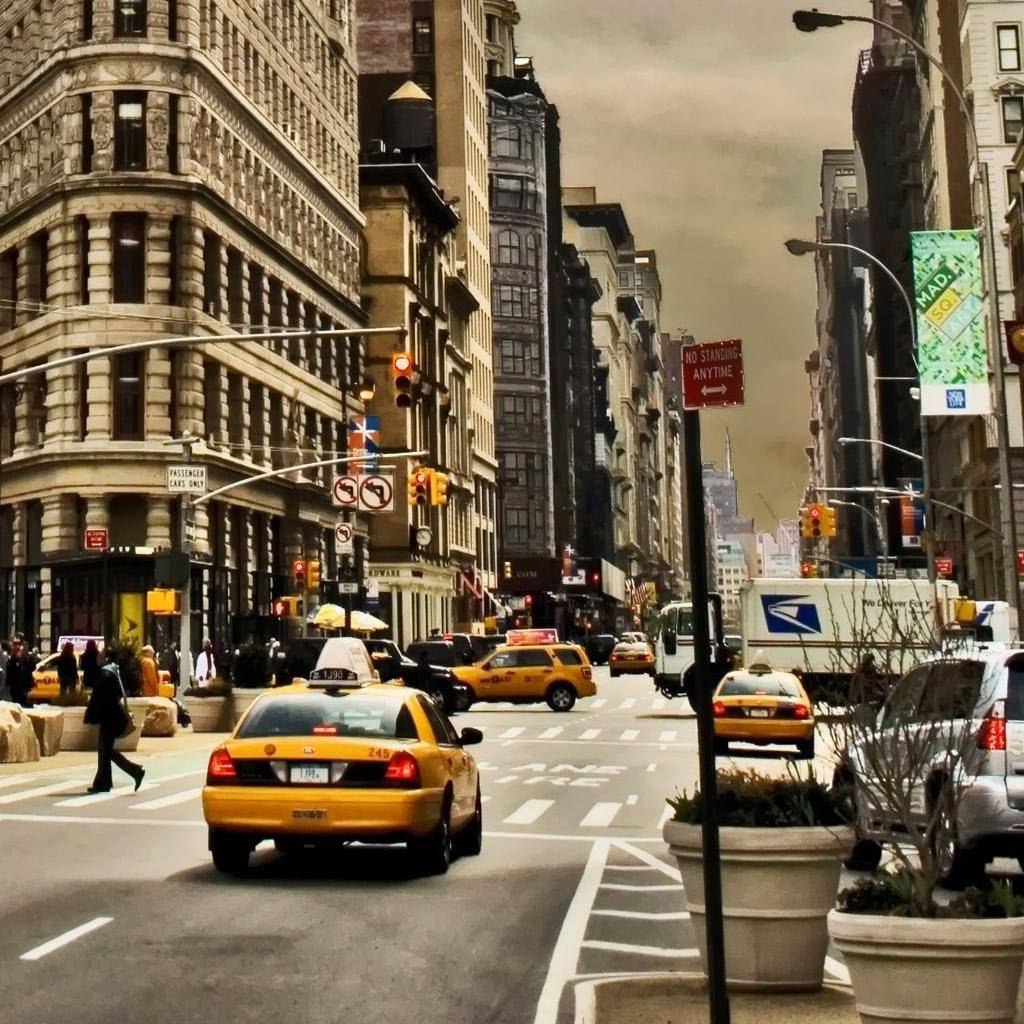 manhattan 桌布 壁紙 — 紐約市一條繁華的街道，兩旁是歷史建築，黃色計程車在陰天下行駛。