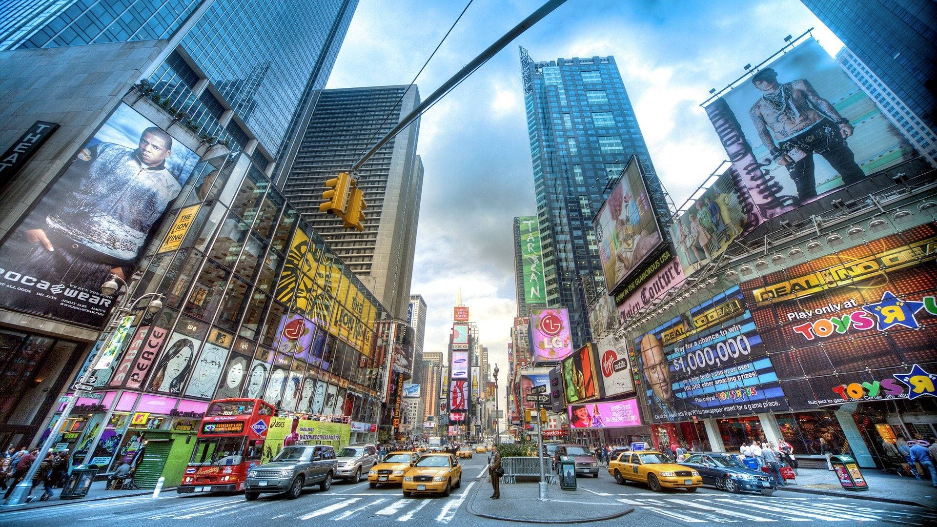 New York Street 桌布 壁紙 — 紐約市一條繁華的街道，高聳的摩天大樓、閃爍的廣告看板和黃色計程車，天空局部多雲。