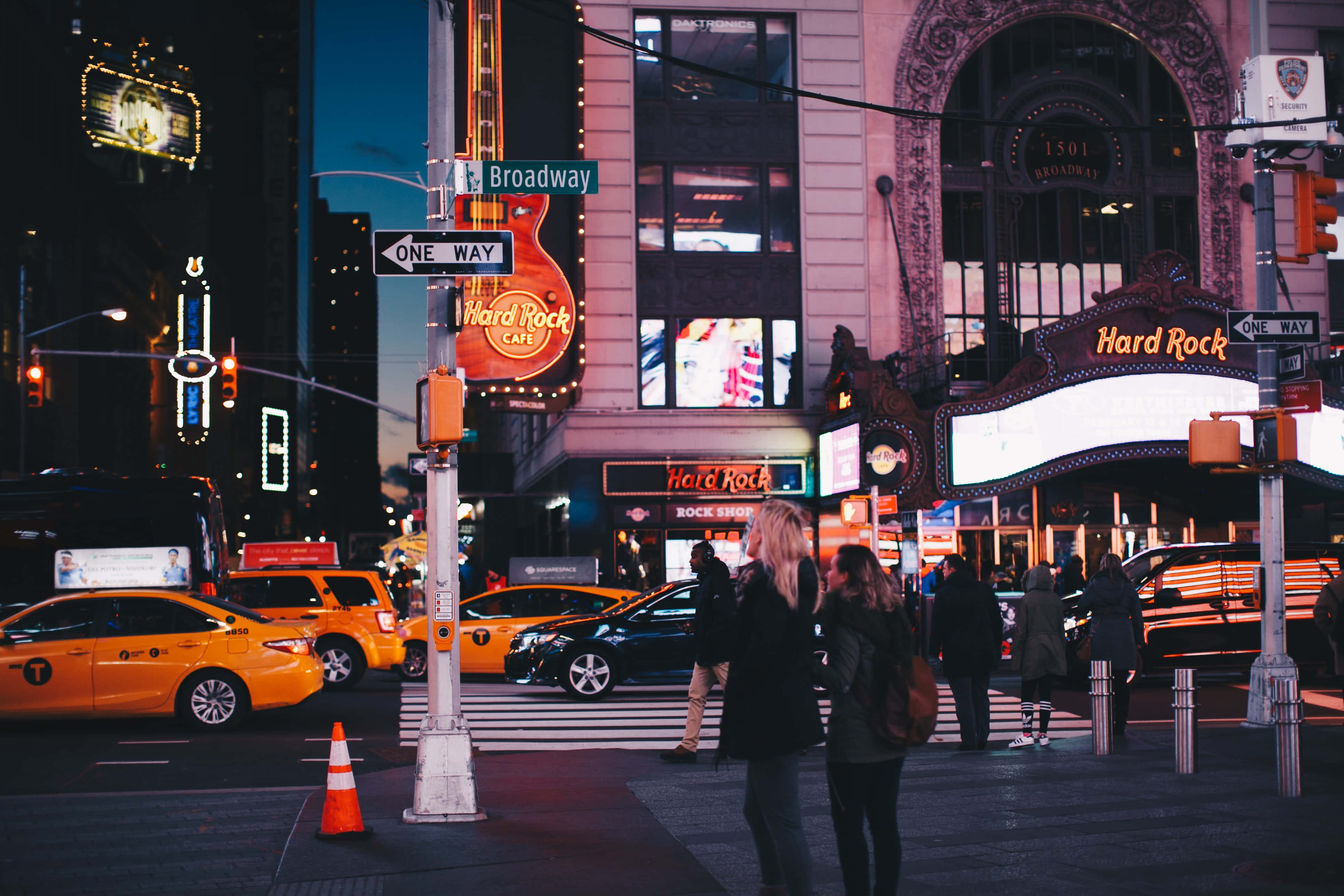 Nyc 桌布 壁紙 — 紐約市充滿活力的夜間街景，帶有發光的Hard Rock Cafe標誌和黃色計程車。