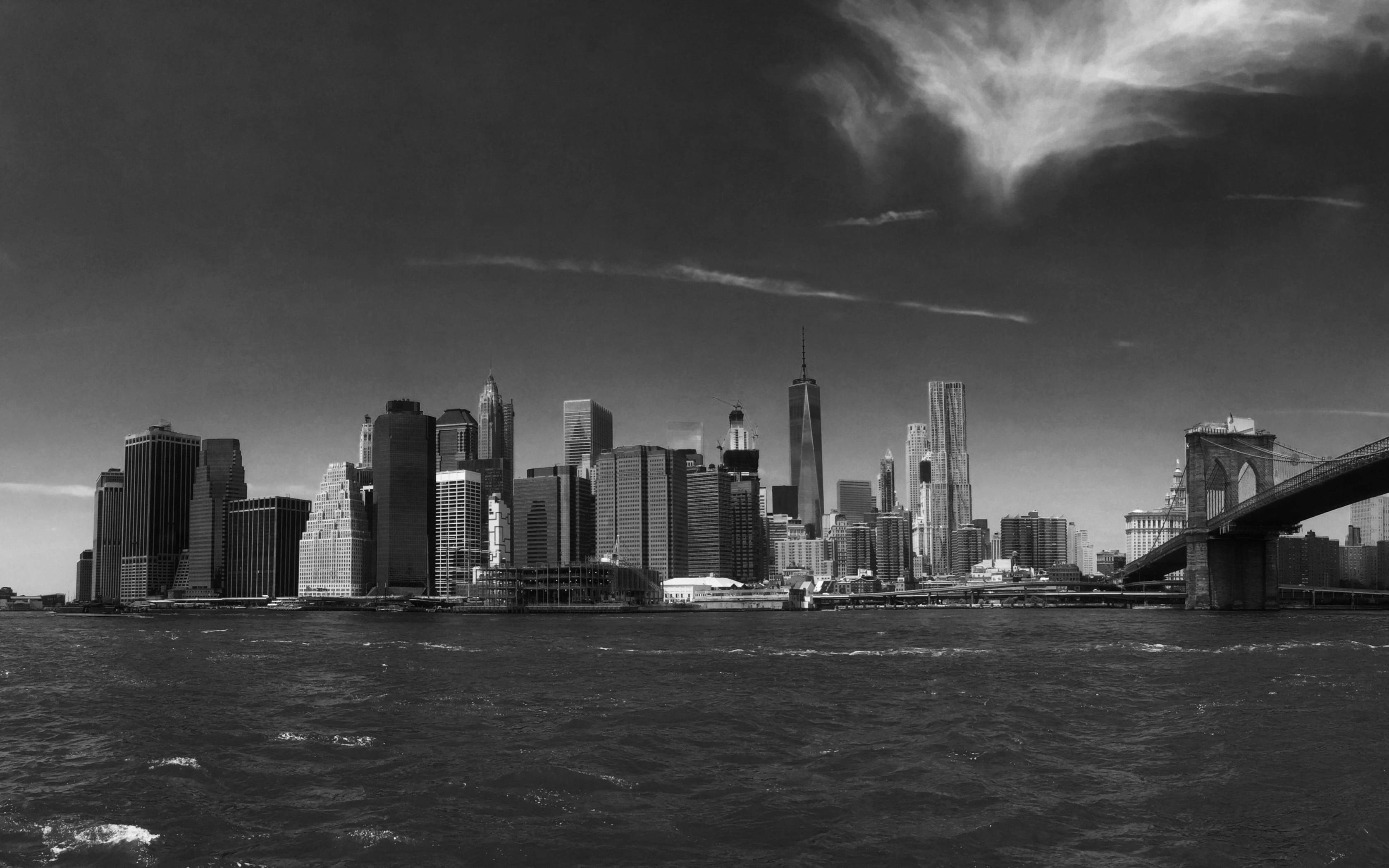 Brooklyn Bridge 桌布 壁紙 — 紐約市單色天際線，布魯克林大橋在戲劇性的暴風雲下橫跨水面。