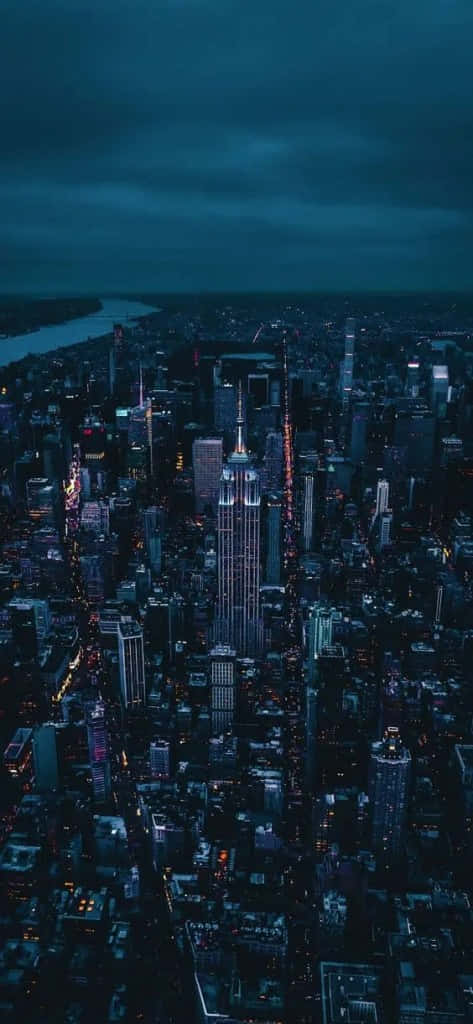 美學 iPhone 壁紙 桌布 壁紙 — 紐約市夜景鳥瞰圖，帝國大廈在黑暗多雲的天空中亮起。