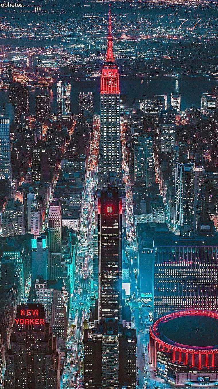 New York City Night iPhone 桌布 壁紙 — 紐約市夜景鳥瞰圖，帝國大廈發出紅光，街道以電光藍照亮。