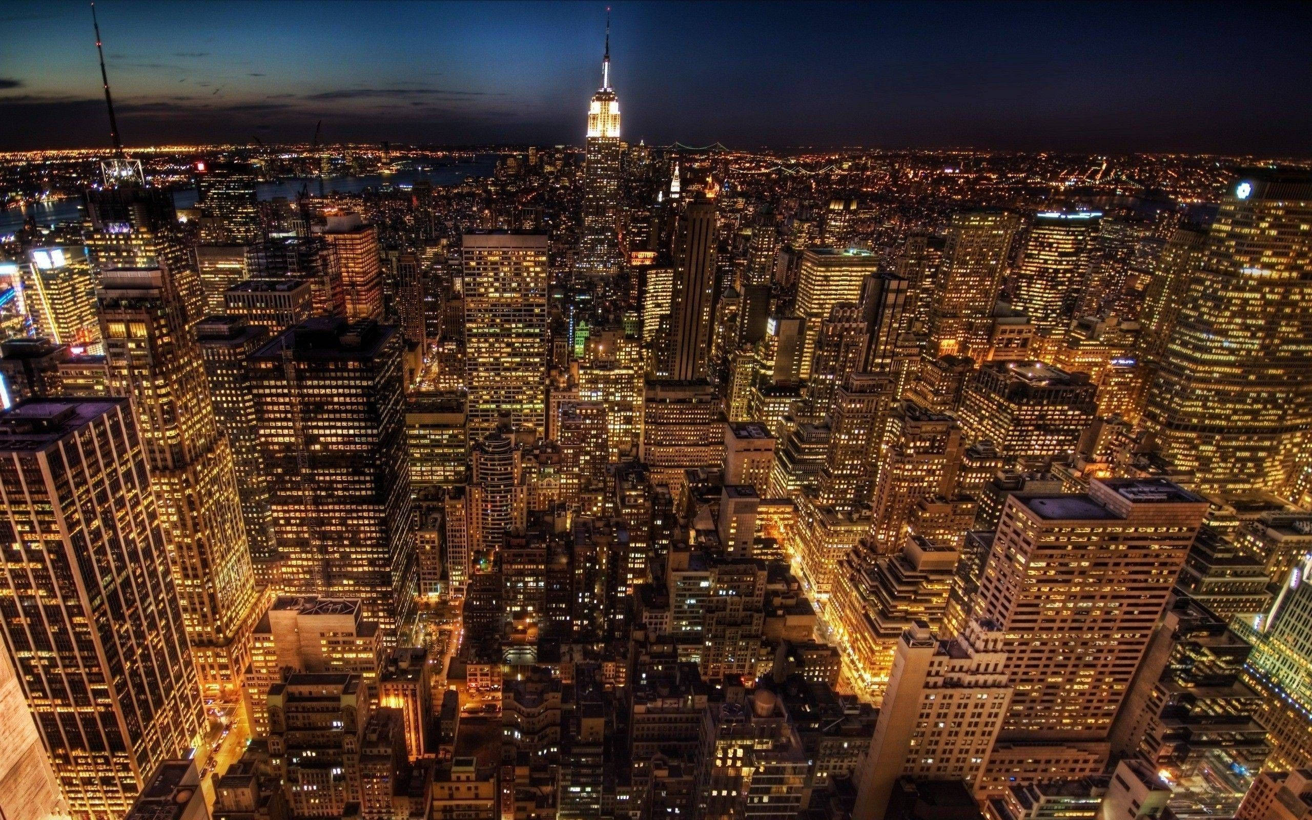 New York Skyline 桌布 壁紙 — 紐約市夜景鳥瞰圖，摩天大樓閃爍，帝國大廈在黑暗的天空中亮起。
