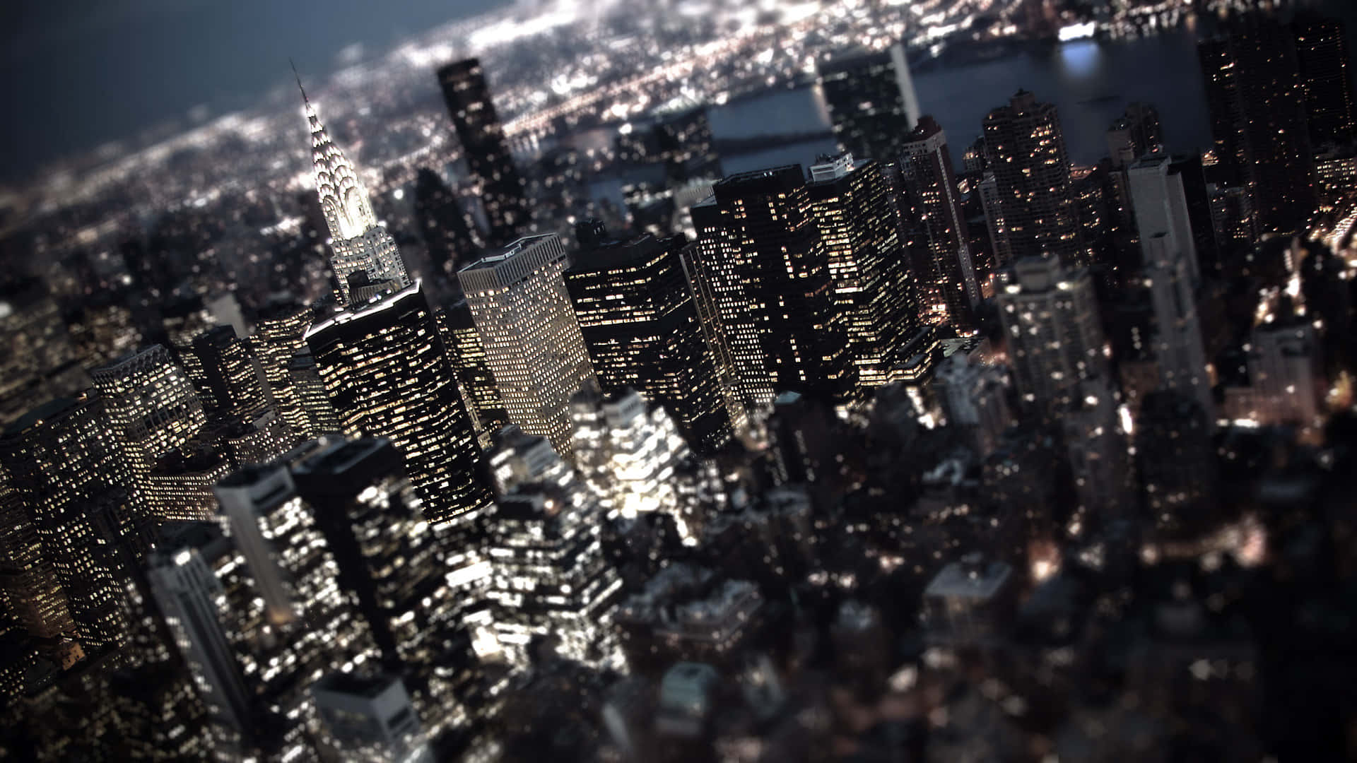 New York Art 桌布 壁紙 — 紐約市夜景鳥瞰圖，燈火通明的摩天大樓和模糊的前景營造出深度感。