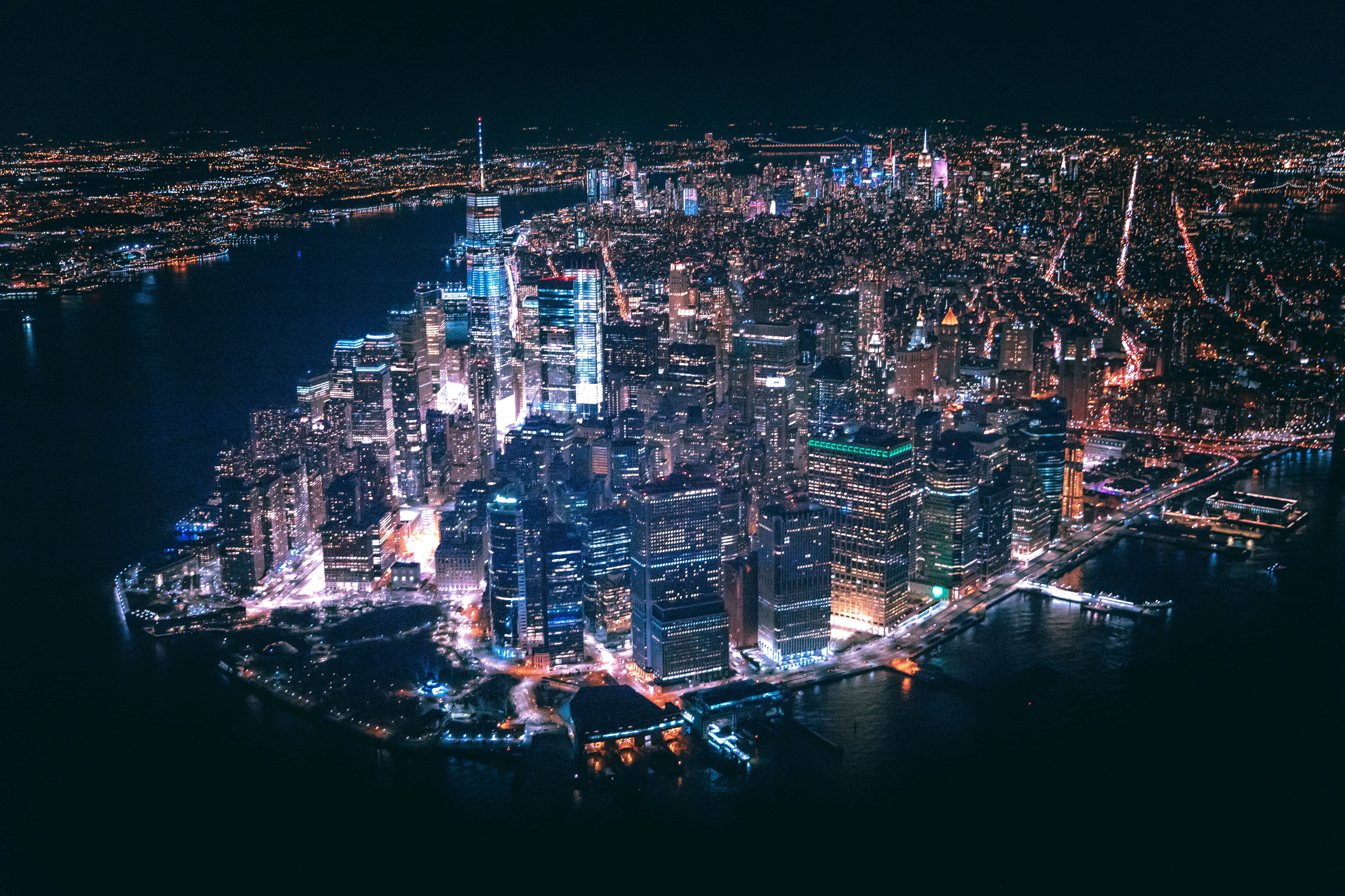 New York Art 桌布 壁紙 — 紐約市夜景鳥瞰圖，閃爍的摩天大樓和倒映城市燈光的黑暗水面。