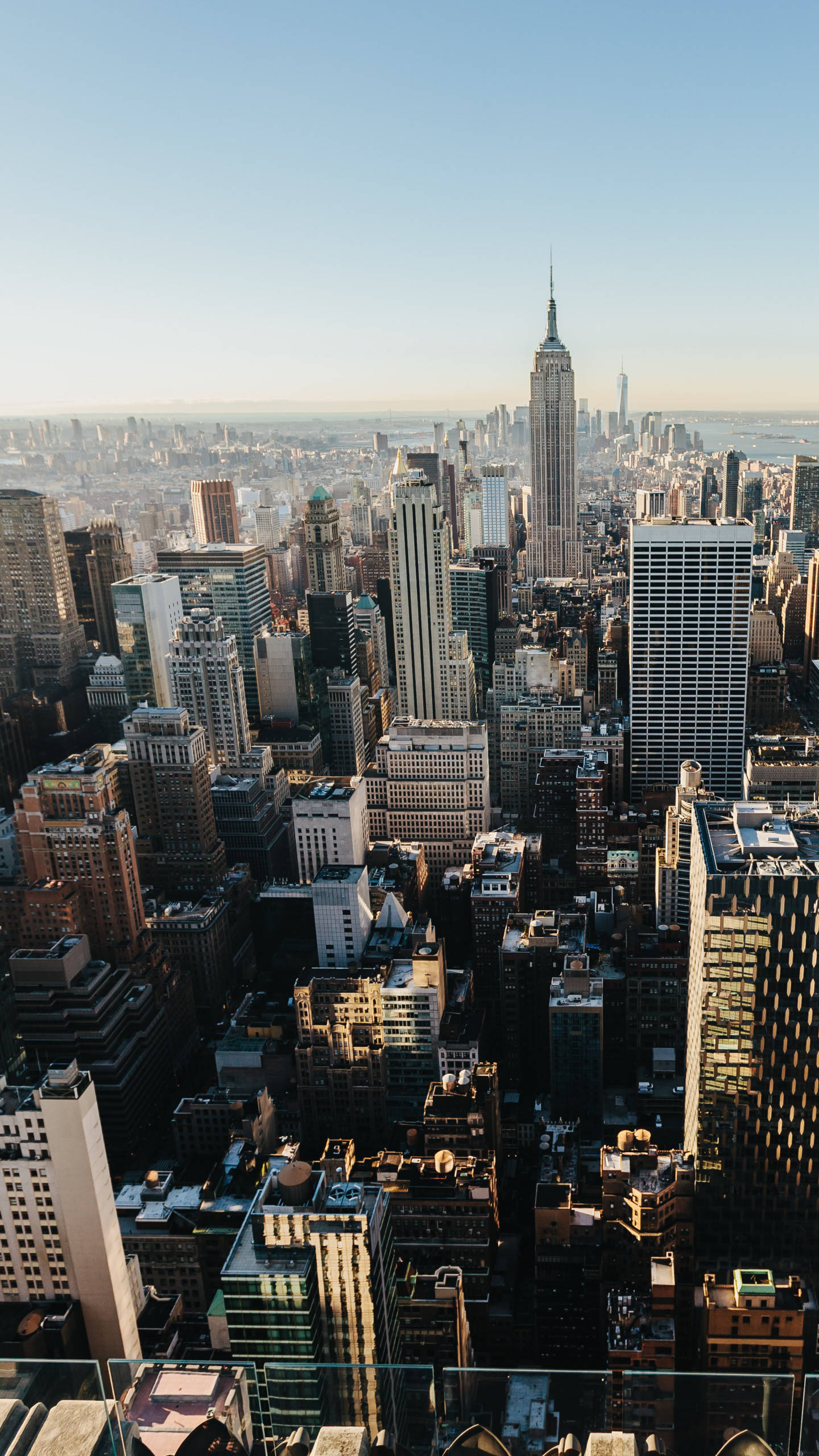 new york city iPhone x 桌布 壁紙 — 紐約市天際線在日出時的鳥瞰圖，帝國大廈聳立在密集的城市建築之上。