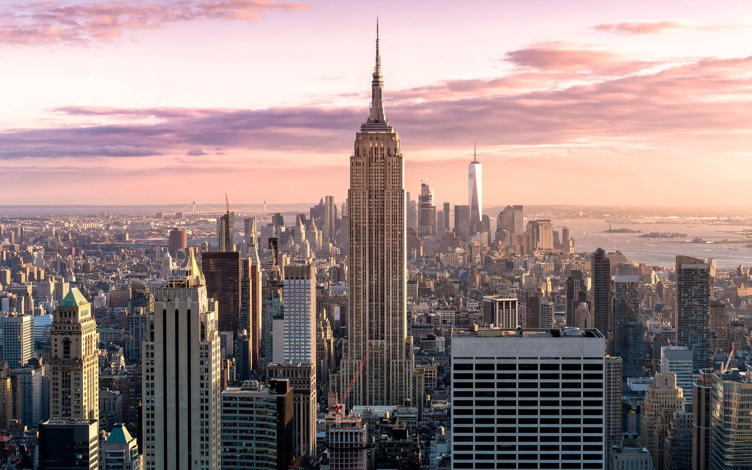 empire state 桌布 壁紙 — 紐約市天際線在日落時的鳥瞰圖，帝國大廈高聳於摩天大樓和水面之上。