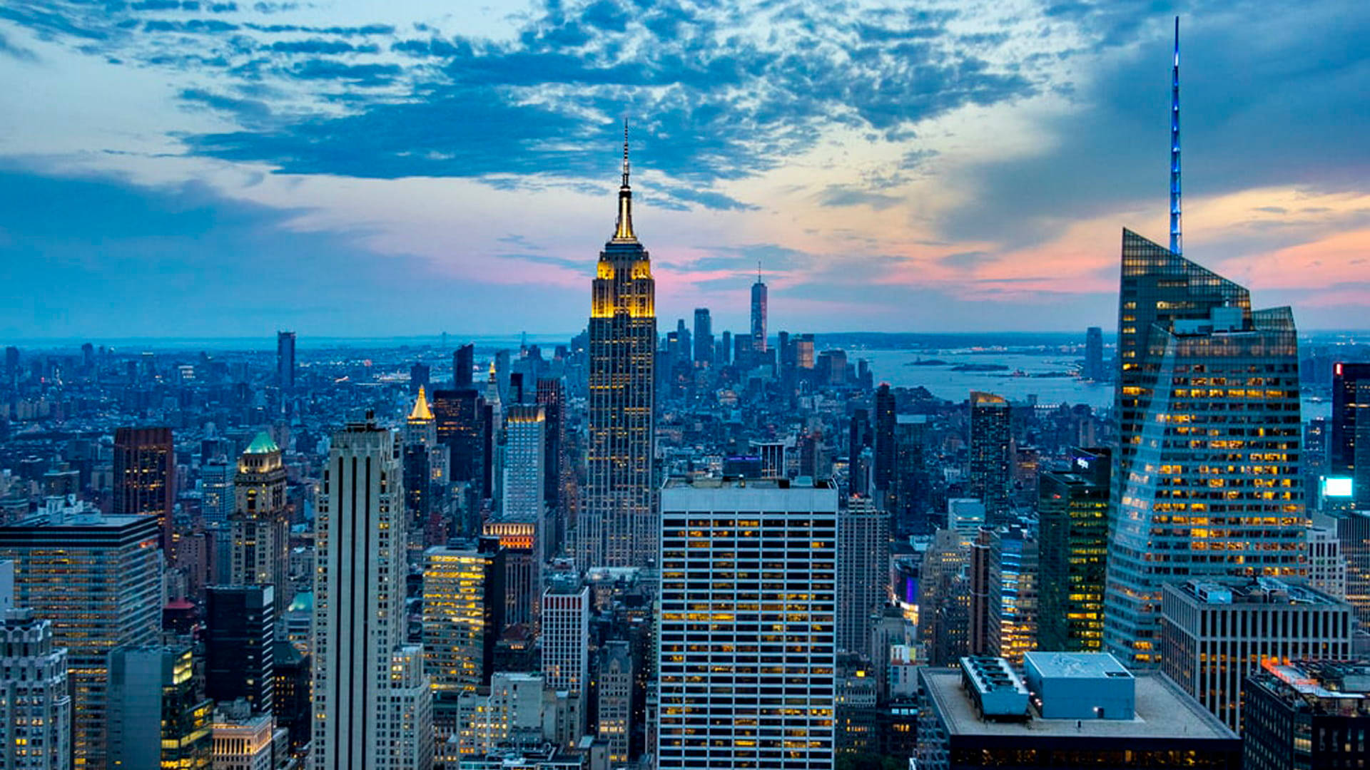 Nyc Aesthetic 桌布 壁紙 — 紐約市天際線在黃昏時分，帝國大廈在戲劇性的藍色和粉紅色天空中閃耀。