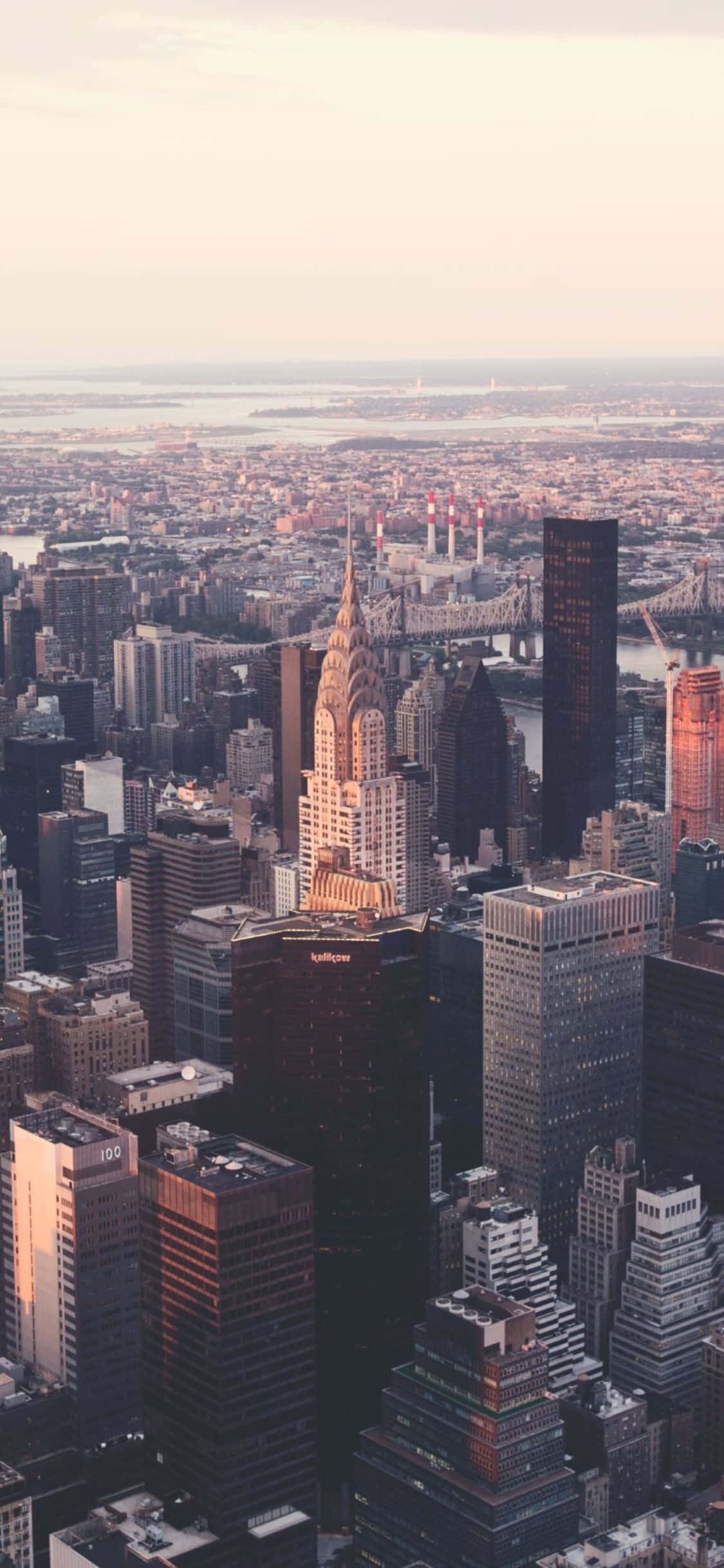 iPhone Xs Ny City 桌布 壁紙 — 紐約市天際線在黃金時刻的鳥瞰圖，克萊斯勒大廈聳立於密集的城市建築之上。