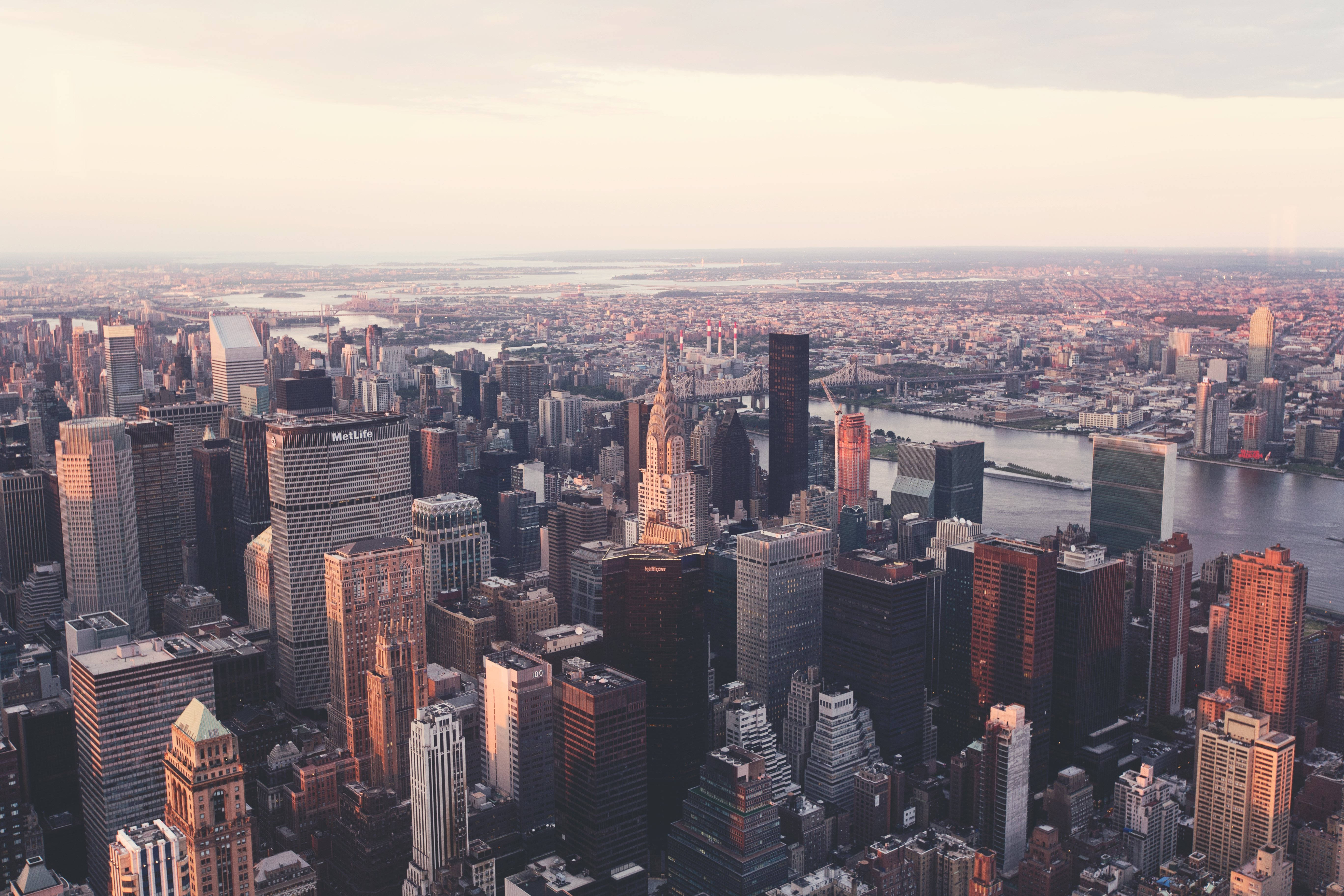 4K New York City 桌布 壁紙 — 紐約市天際線在黃金時刻的鳥瞰圖，摩天大樓在河流和橋樑上反射溫暖的光線。