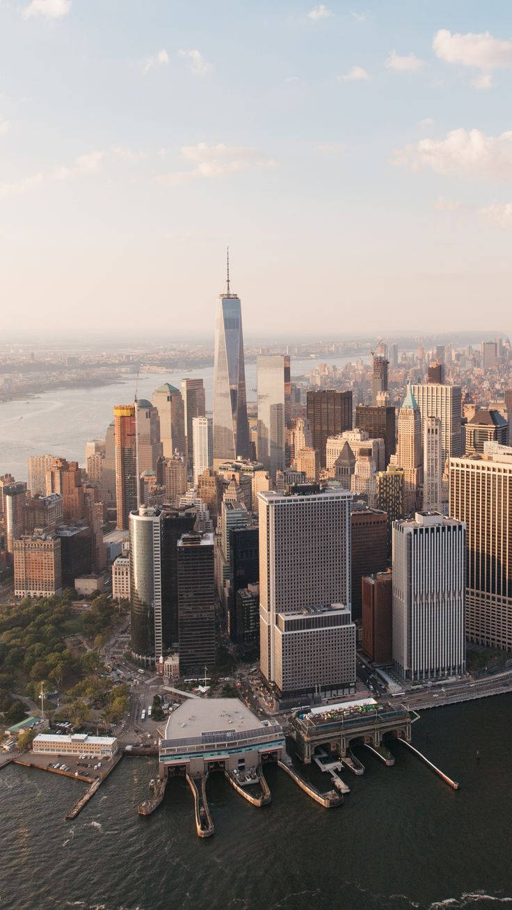 New York 桌布 壁紙 — 紐約市天際線在黃金時刻的鳥瞰圖，世界貿易中心一號大樓聳立於摩天大樓和海港水域之上。